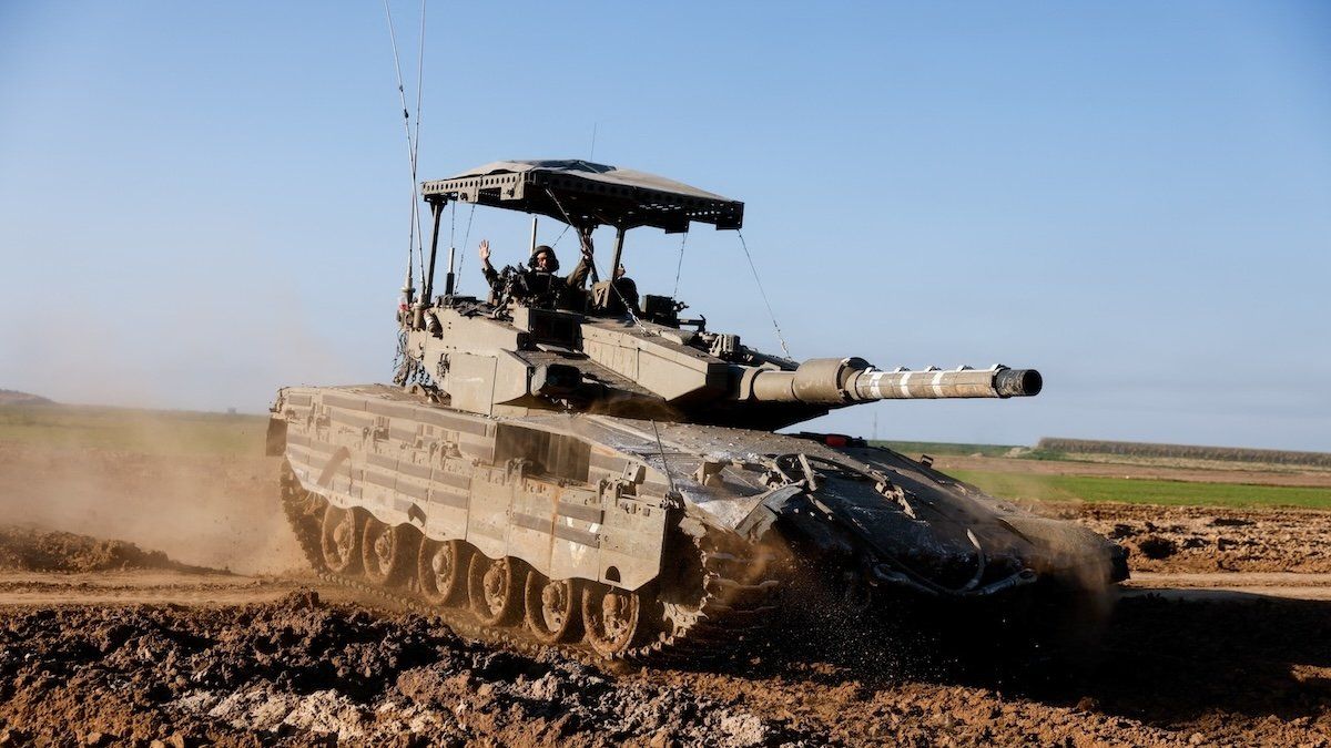 An Israeli soldier gestures atop of a tank near the southern Gaza Strip border, amid the ongoing conflict between Israel and the Palestinian Islamist group Hamas, as seen from Israel, February 7, 2024.