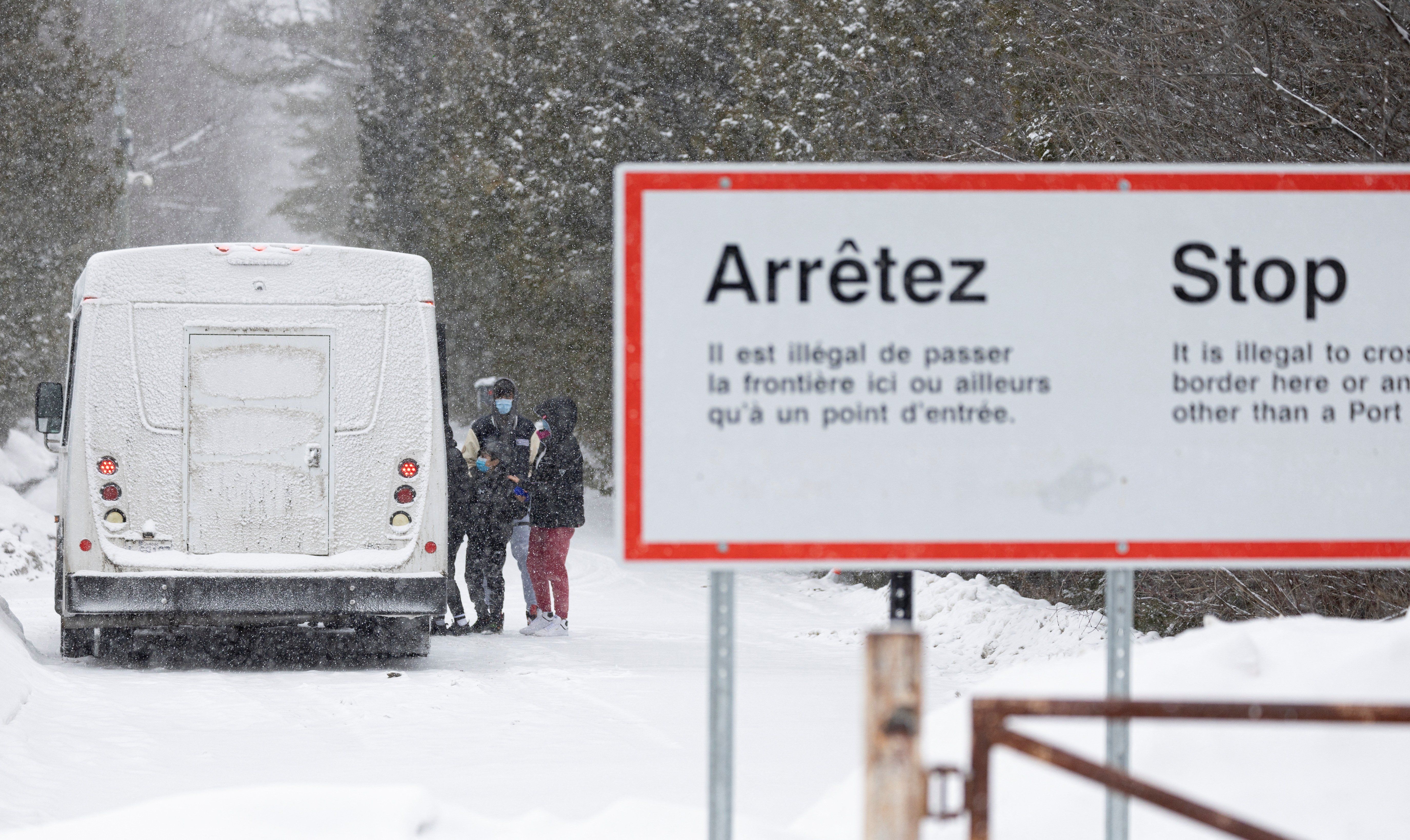 Asylum-seekers board a bus after crossing into Canada from the US in Champlain, New York.