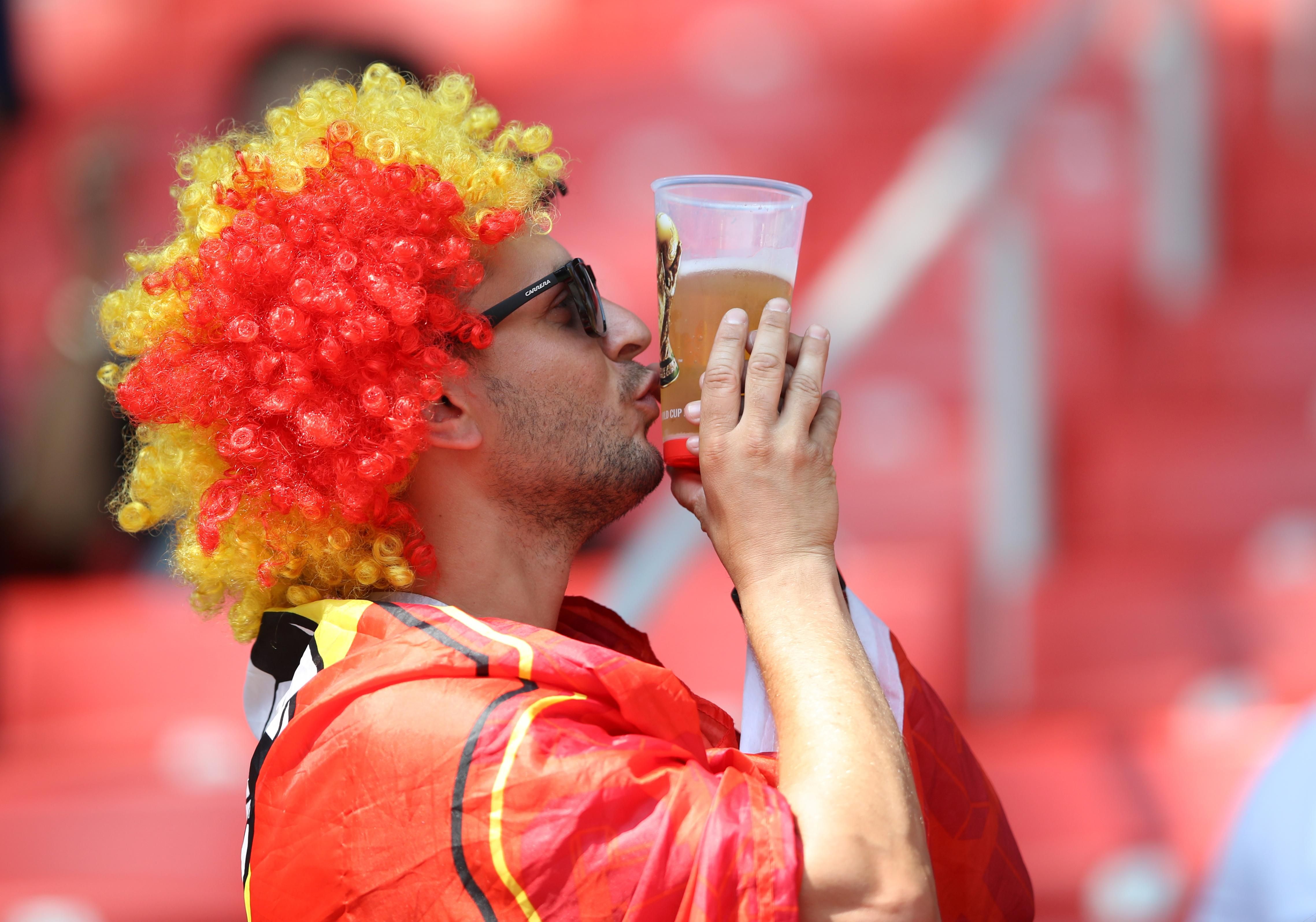 Belgium fan kisses World Cup insignia on his plastic glass of beer before a match at the 2018 Russia World Cup.