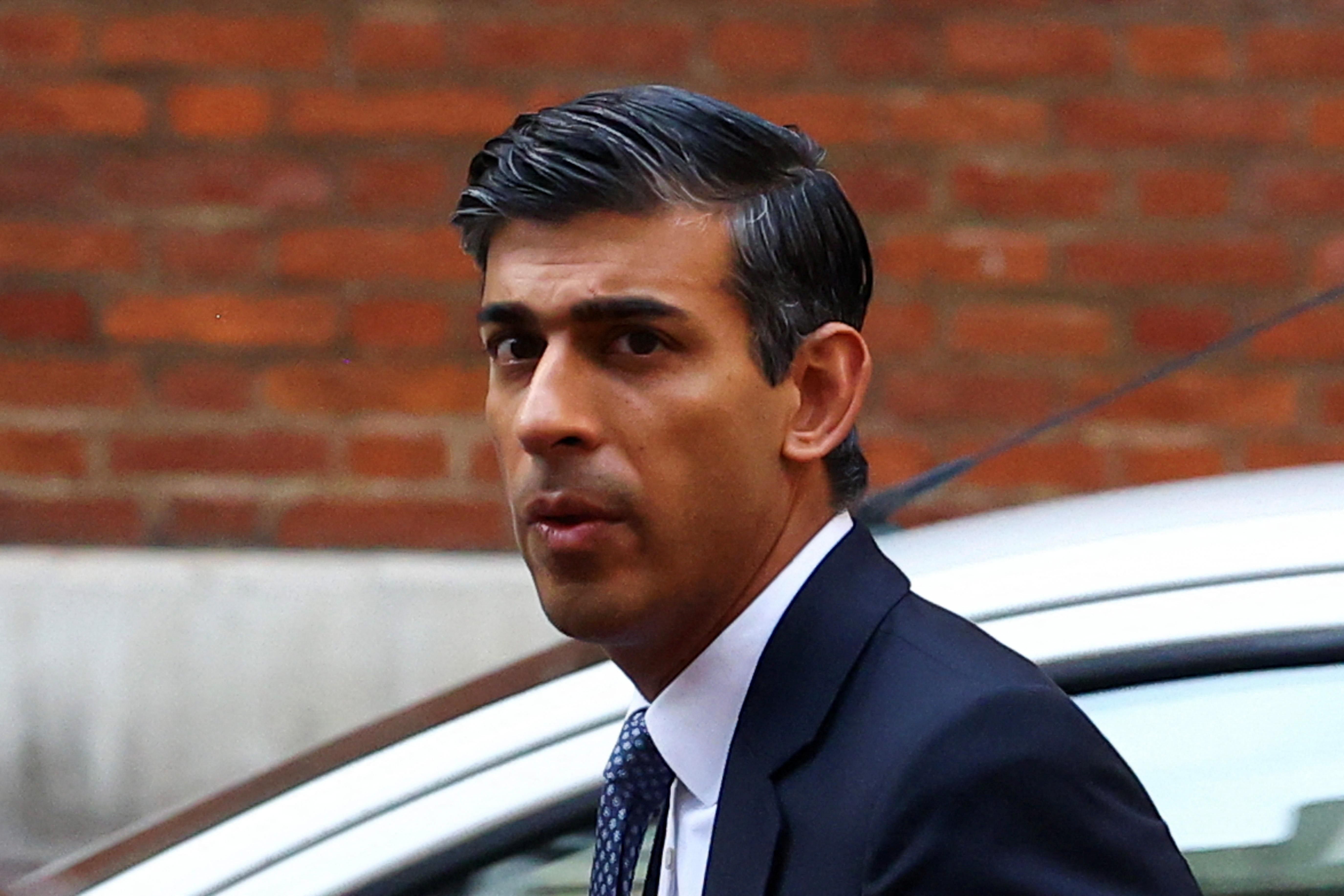 British PM candidate Rishi Sunak walks next to his campaign headquarters in London.