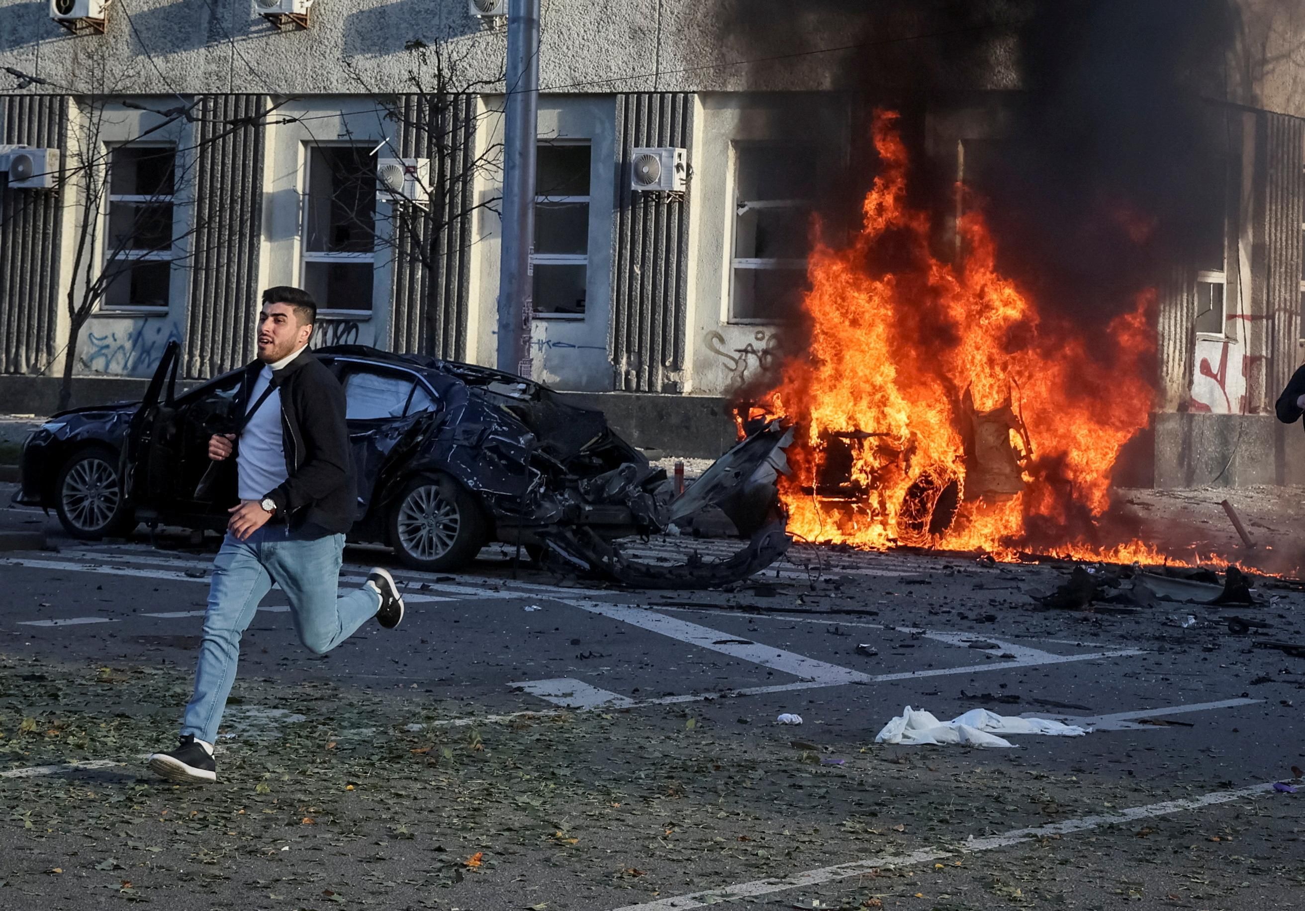 Cars burn after a Russian military strike in central Kyiv.