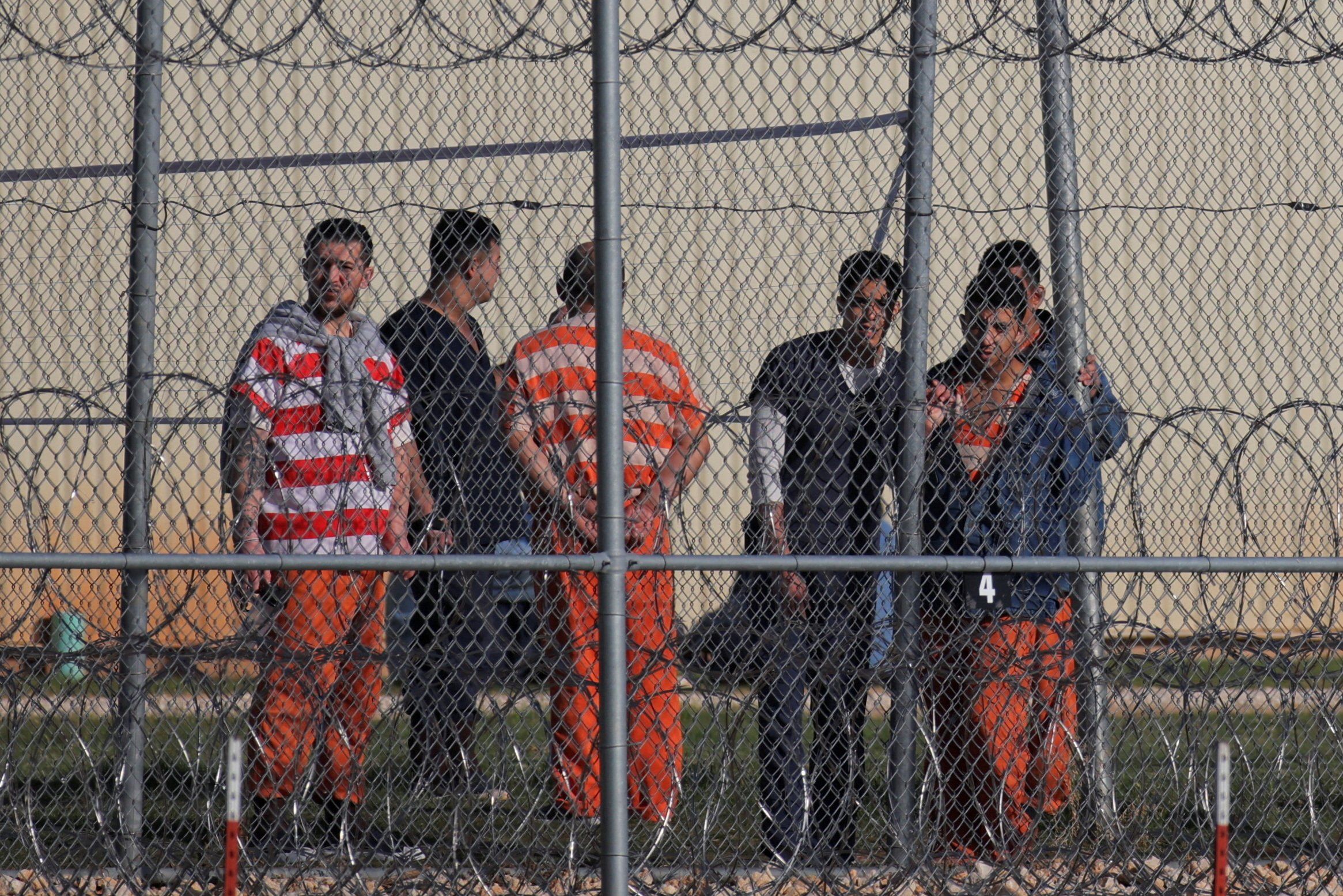 ​Detainees stand behind a fence at the Bluebonnet Detention Facility, where Venezuelans at the center of a Supreme Court ruling on deportation are held, in Anson, Texas, U.S. April 22, 2025.  