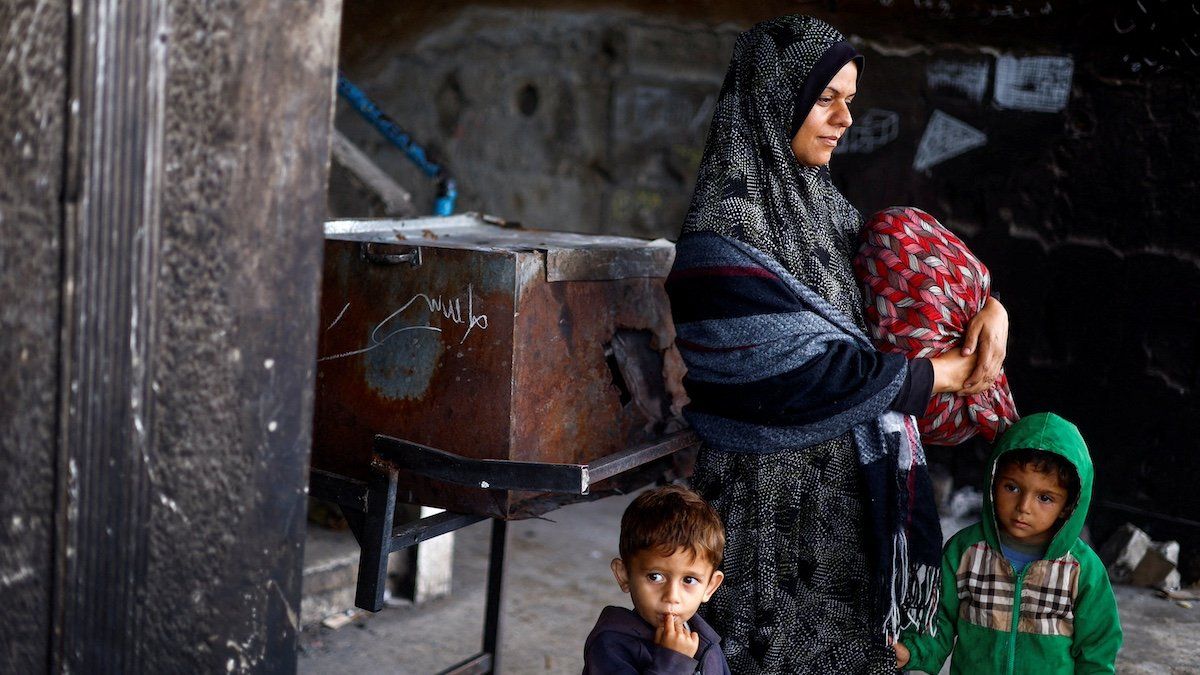 ​Displaced Palestinian woman Mai Anseir stands with children at a school where they shelter as they prepare to flee Rafah after Israeli forces launched a ground and air operation in the eastern part of the southern Gaza City, amid the ongoing conflict between Israel and Hamas, in Rafah, in the southern Gaza Strip May 13, 2024. 