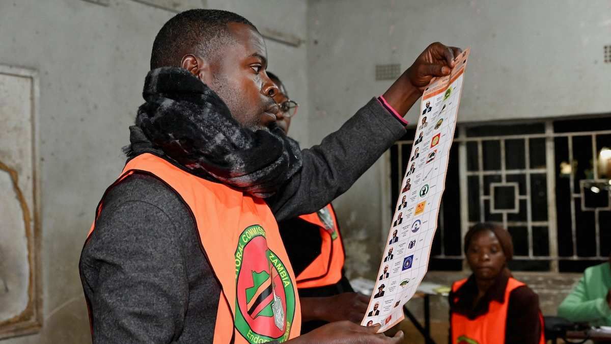 Election officials display a ballot paper while sorting and counting votes after polls close at a polling station during Zambia's general elections.