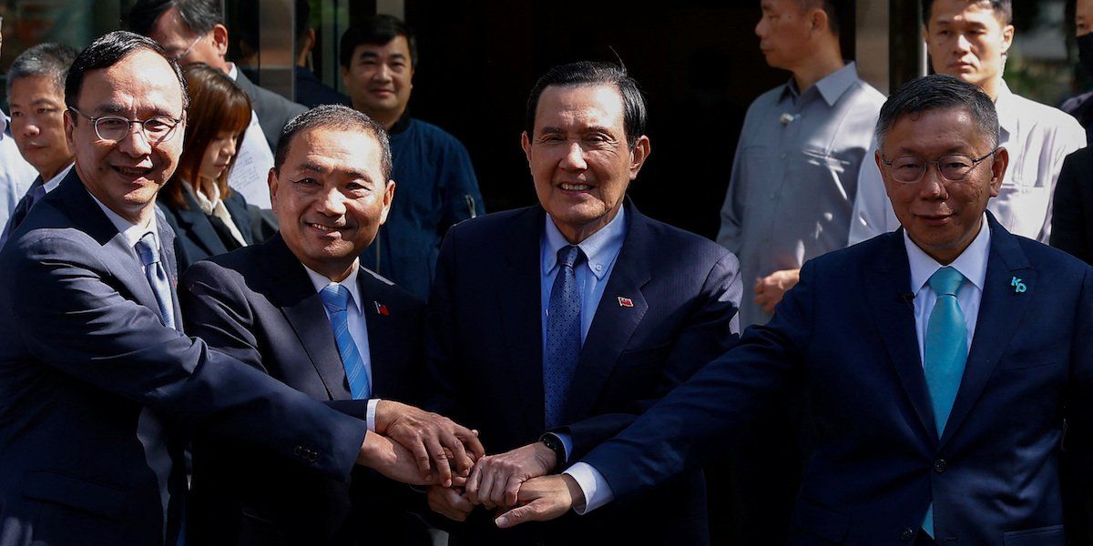 Eric Chu, Hou Yu-ih, Ma Ying-jeou and Ko Wen-je hold hands as they pose for a group photo in Taipei, Taiwan on November 15, 2023.