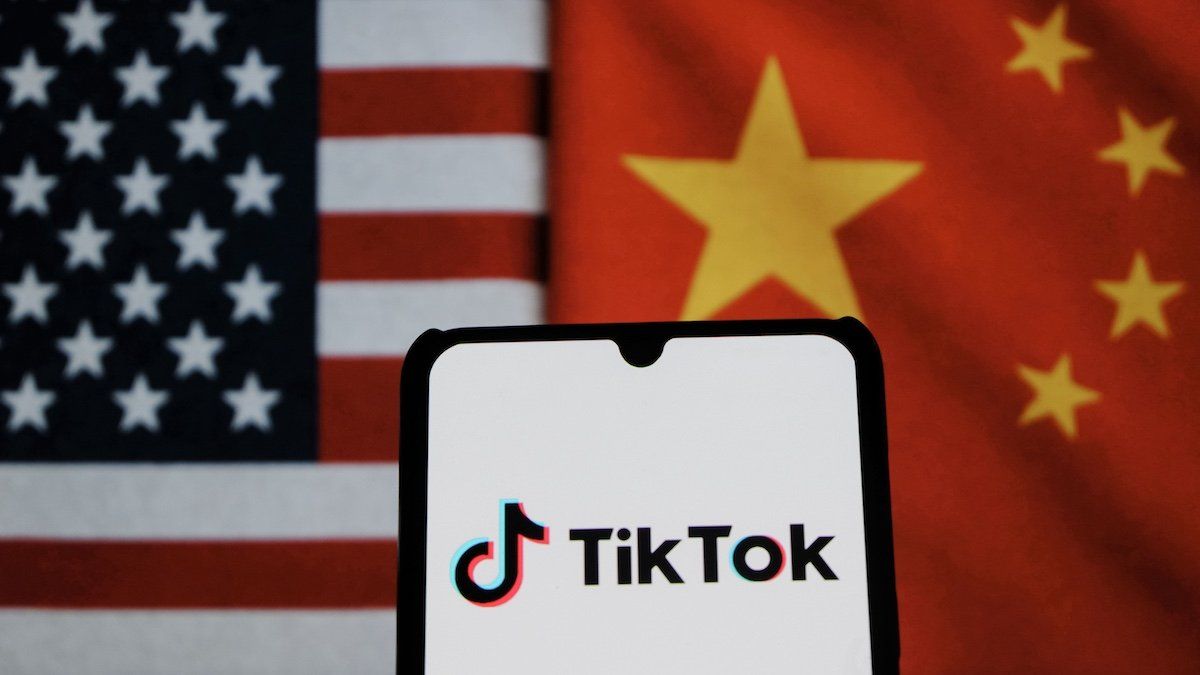 ​In this photo illustration, TikTok logo is displayed on a smartphone with the national flags of China and the United States in the background.