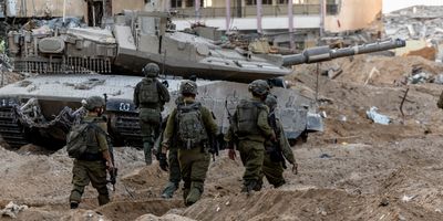 Israeli soldiers walk through rubble, amid the ongoing ground invasion against Palestinian Islamist group Hamas in the northern Gaza Strip, November 8, 2023. 