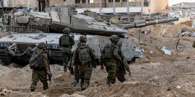 Israeli soldiers walk through rubble, amid the ongoing ground invasion against Palestinian Islamist group Hamas in the northern Gaza Strip, November 8, 2023.