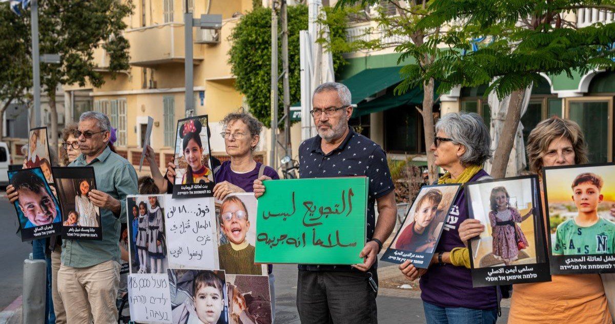 ​Israelis hold up photos of dead children in Gaza at demonstration in Tel Aviv, May 7th, 2025. 