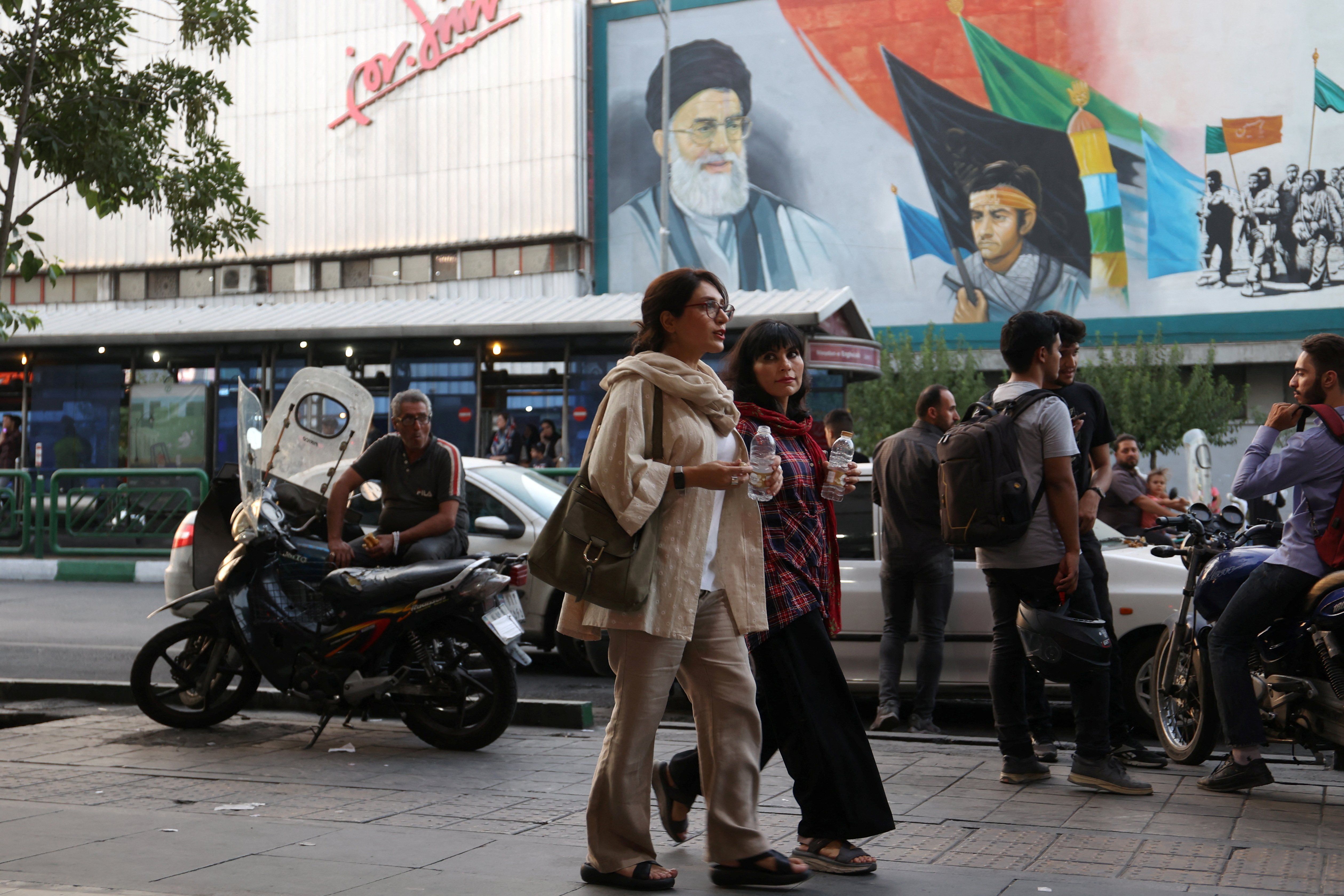 ​Iranian women walk down a street with their hair exposed despite the revival of the morality police in Tehran, Iran. 