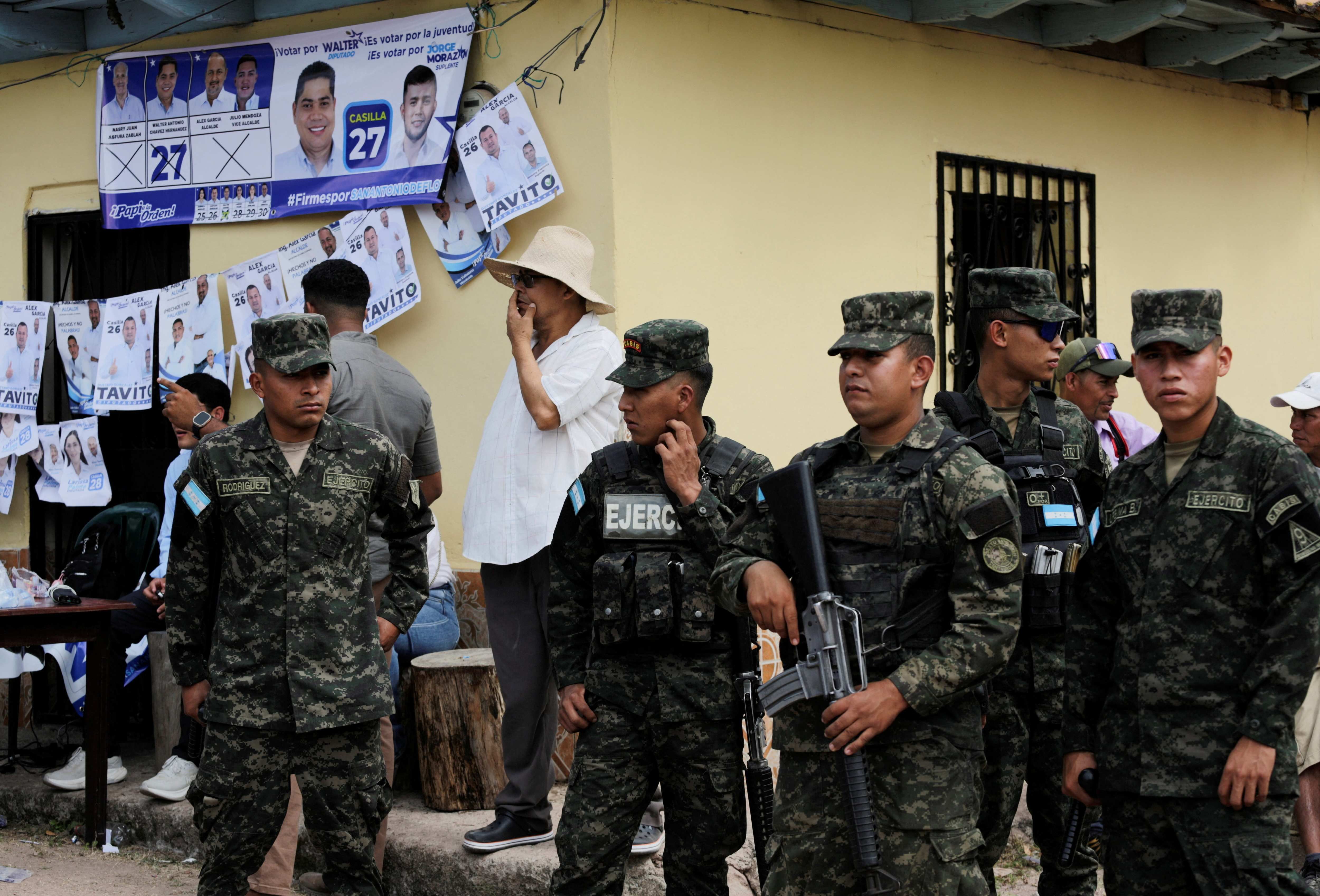 Members of security forces stand guard outside a polliong station, a week late in a special election, after the local governing party kept voting closed on election day, amid accusations of sabotage and fraud, in a presidential race still too close to call as counting continues, in San Antonio de Flores, Honduras, December 7, 2025. 