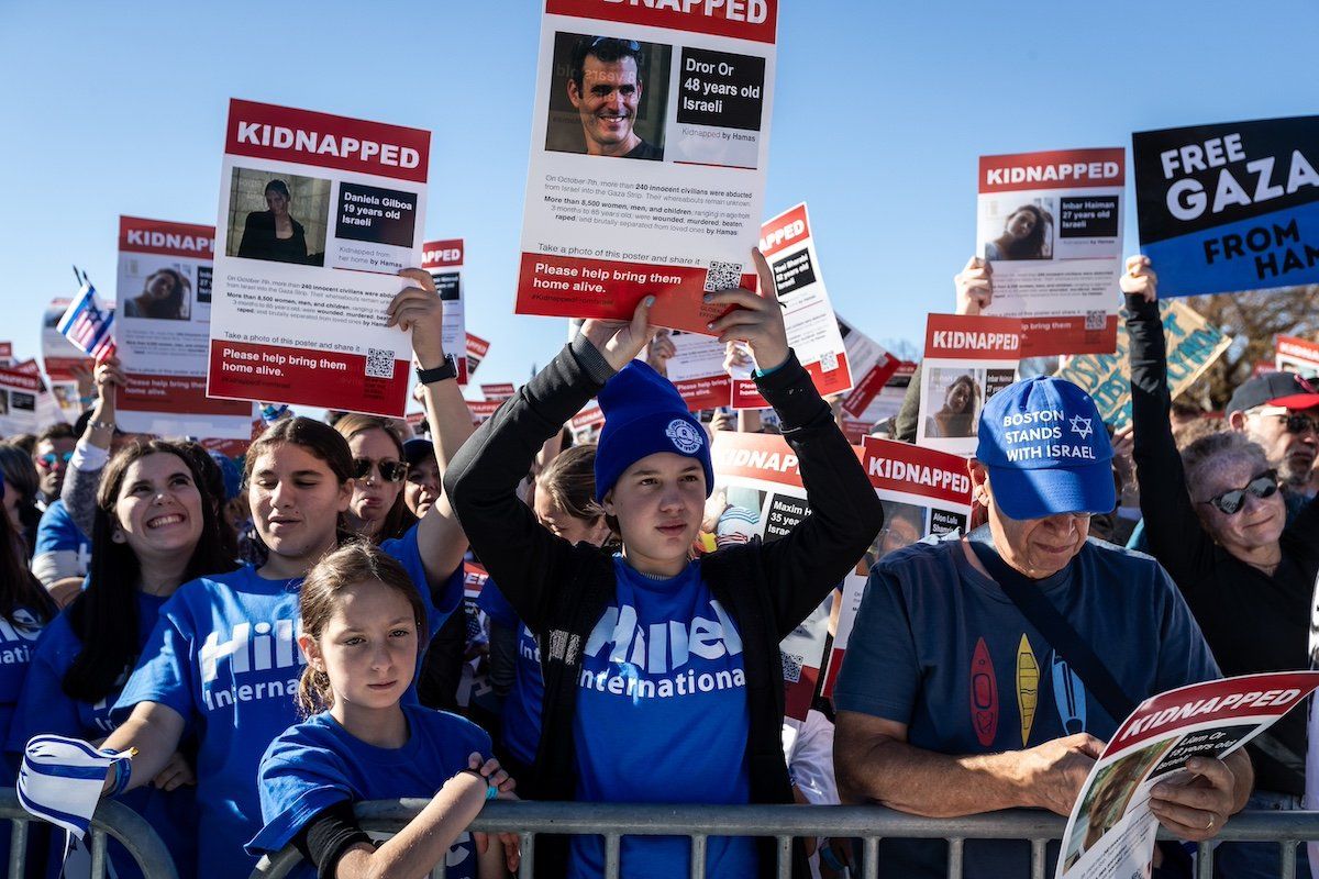 Members pf the Jewish youth group, Hillel, raise posters of hostages during a demonstration in support of Israel on the National Mall attended by tens of thousands of people.