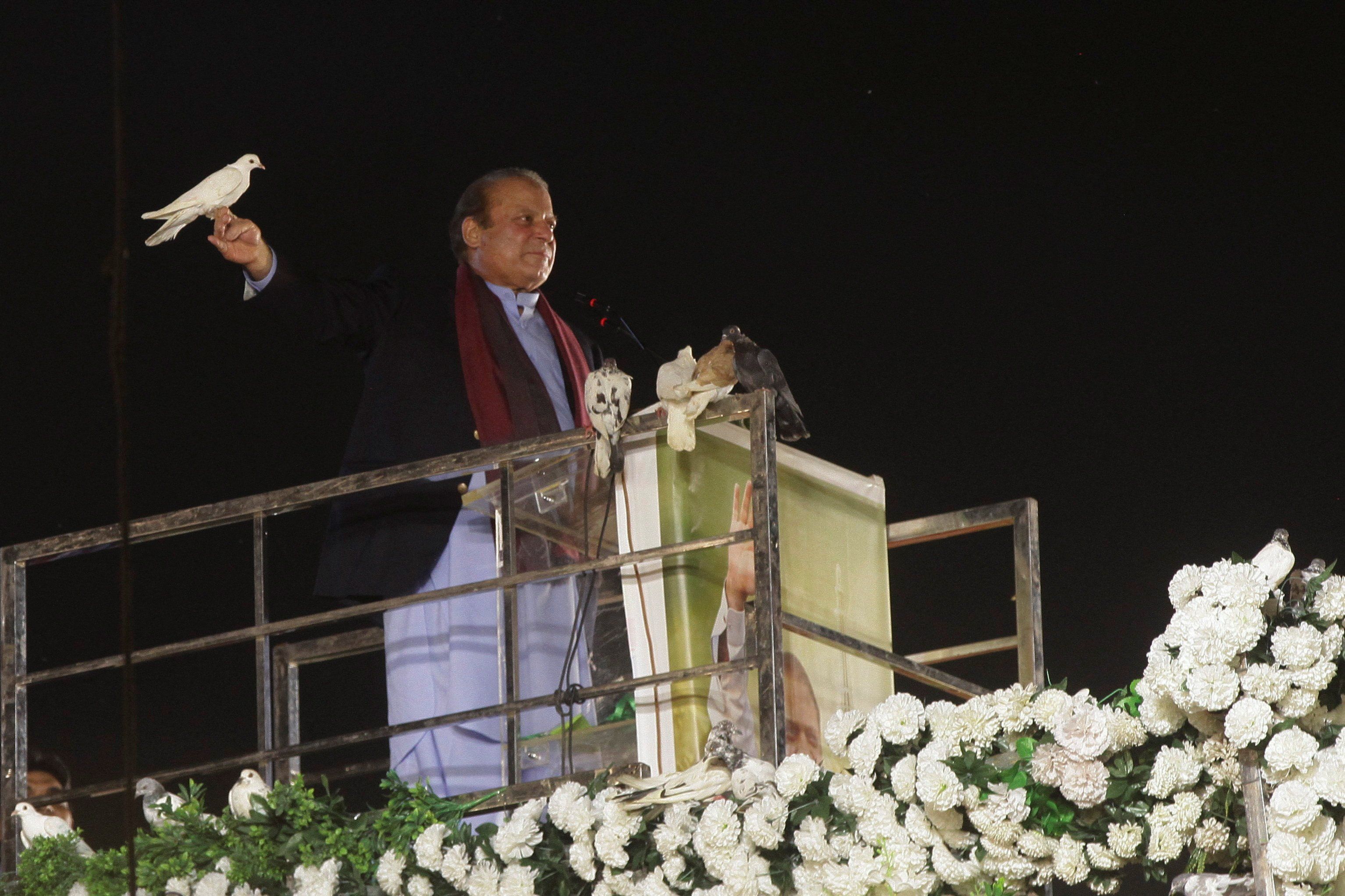​Pakistan's former Prime Minister Nawaz Sharif prepares to release a pigeon in front of supporters in Lahore after returning from self-imposed exile on Oct. 21, 2023. 
