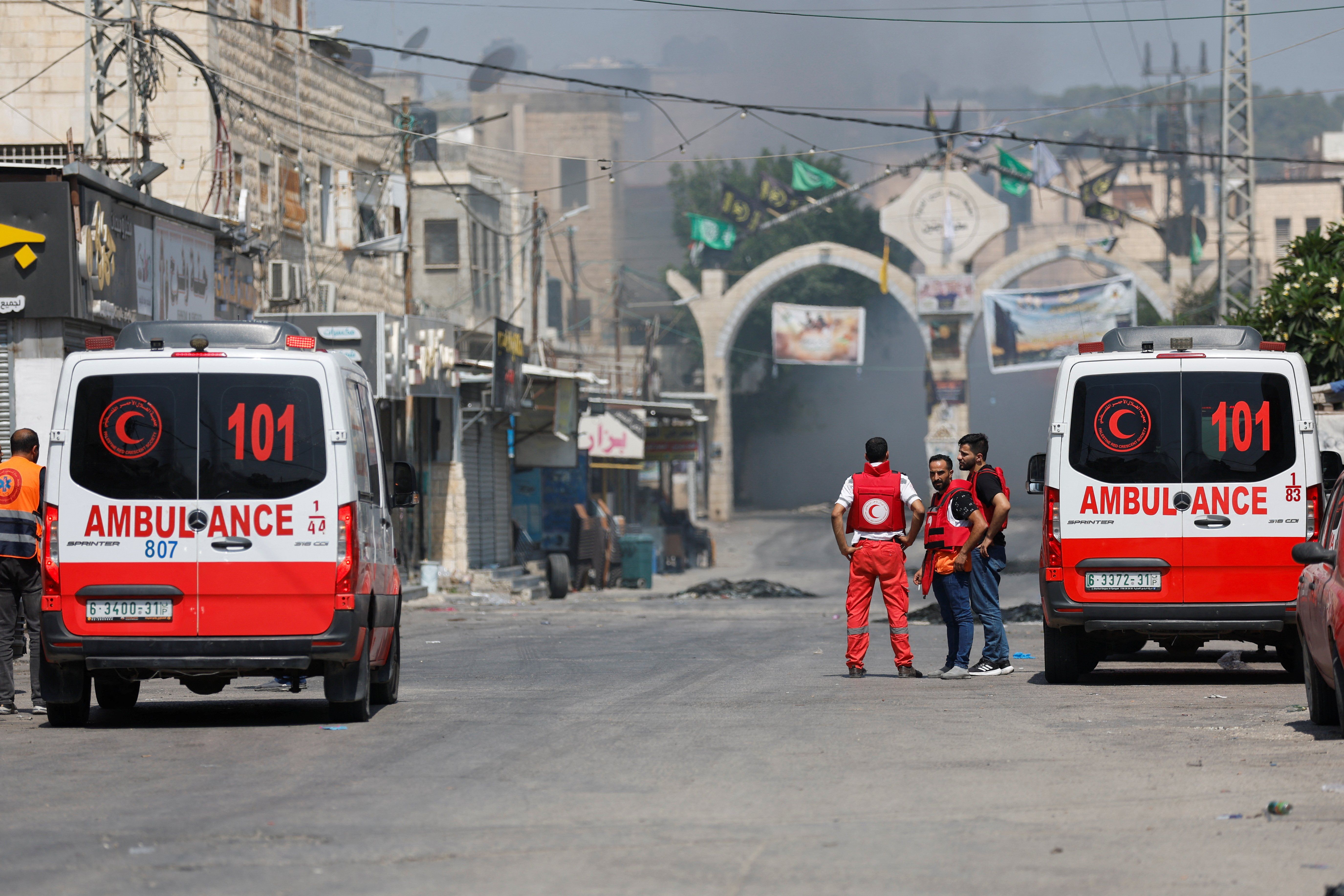 Palestinian medics stand by as smoke rises during an Israeli military operation in Jenin.