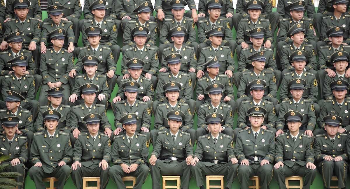 Paramilitary police cadets sit in rows as they watch a parade performance to mark the 20th anniversary of the founding of their military school in Kunming, Yunnan province July 8, 2011.