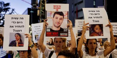 Protesters hold signs demanding the liberation of hostages being held in the Gaza Strip after they were seized by Hamas gunmen on Oct. 7, in Tel Aviv, on Nov. 21, 2023, just hours before the announcement of a four-day cease-fire.