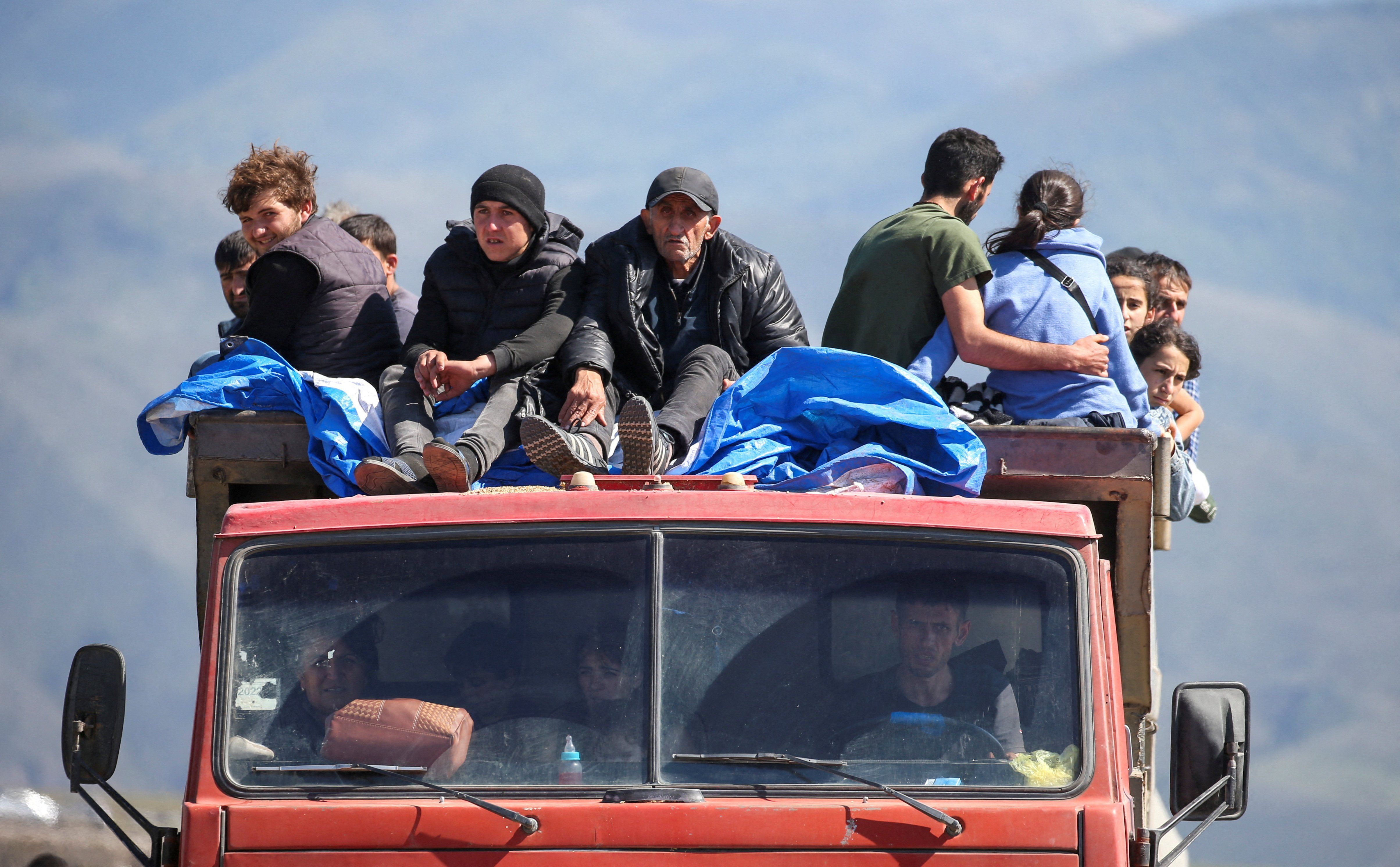 Refugees from Nagorno-Karabakh region ride in a truck upon their arrival at the border village of Kornidzor, Armenia, September 27, 2023.