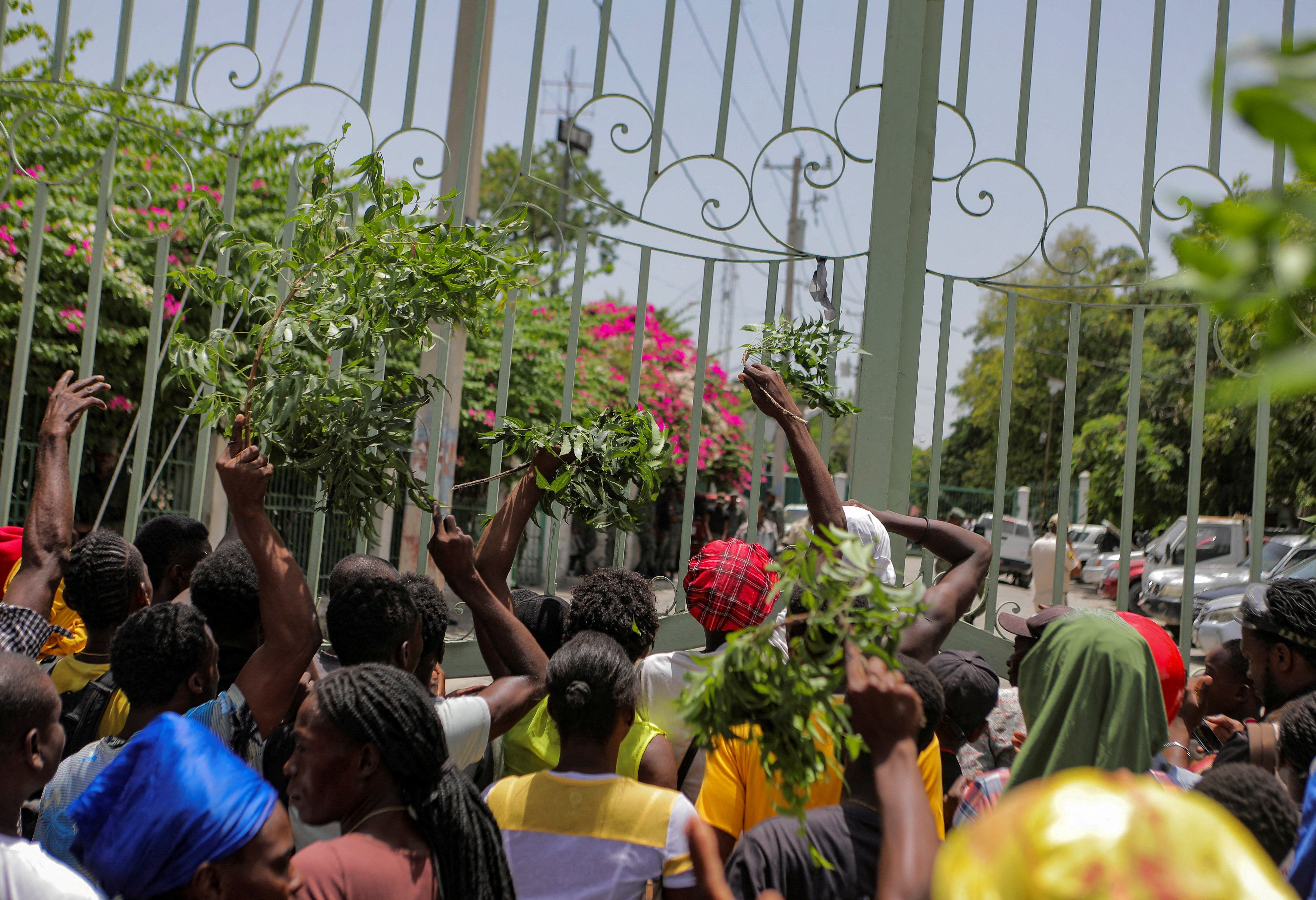 Residents of the Carrefour Feuilles neighborhood gather outside a military base demanding help after they had to flee their homes when gangs took over, in Port-au-Prince, Haiti, in August 2023. 