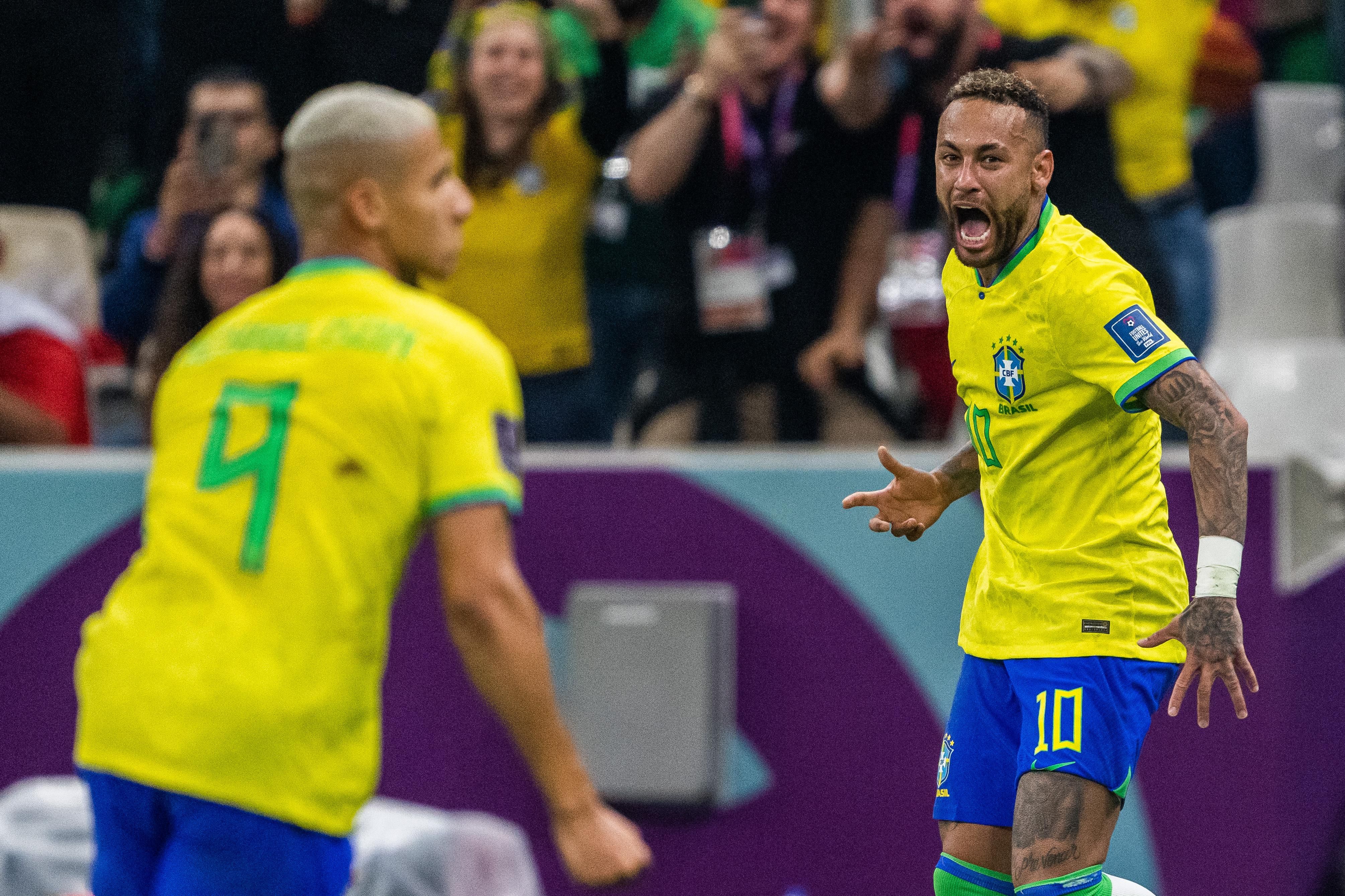 Richarlison (L) and Neymar (R) of Brazil celebrate after scoring the first goal during the FIFA World Cup 2022 match against Serbia in Doha.