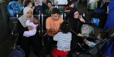 Scores of foreign passport holders trapped in Gaza started leaving the war-torn Palestinian territory on Nov. 1 -- some are seen here waiting at the Rafah border crossing in the southern Gaza Strip before crossing into Egypt.