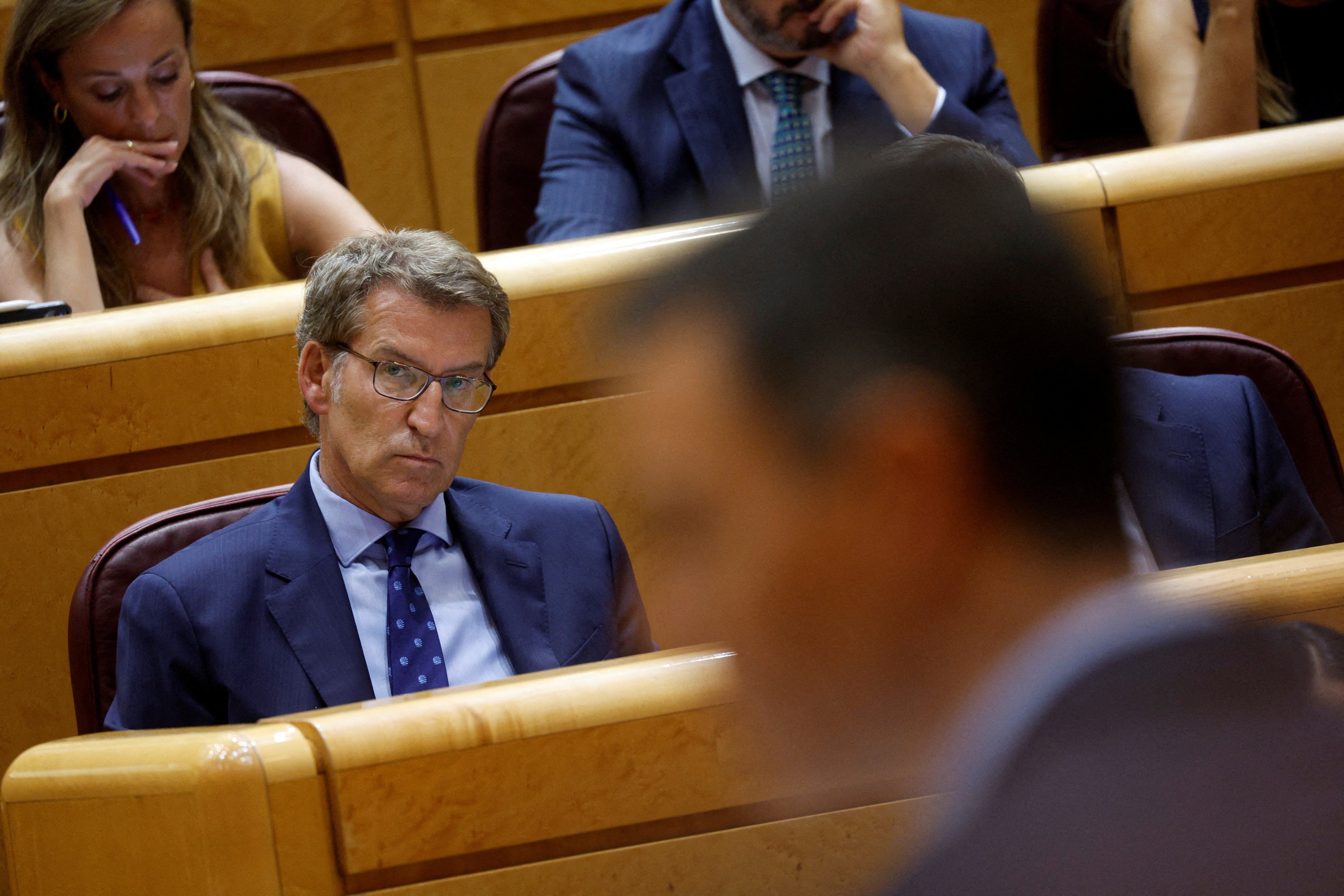 Spain's opposition People's Party leader Alberto Nunez Feijoo listens to PM Pedro Sanchez speak during a session at the Senate in Madrid.