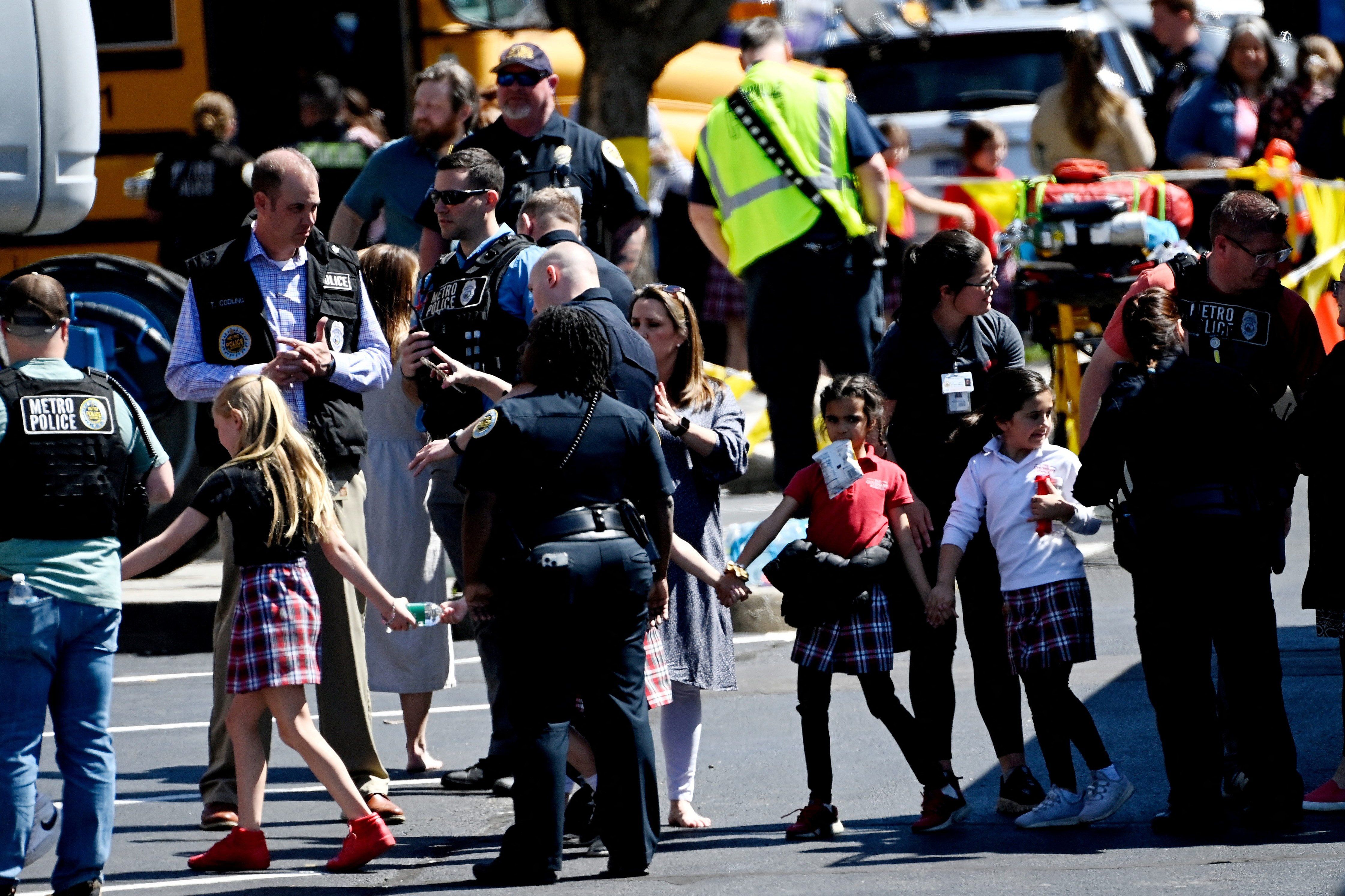 Students from the Covenant School in Nashville, Tenn., hold hands after getting off a bus to meet their parents at the reunification site following a mass shooting. 