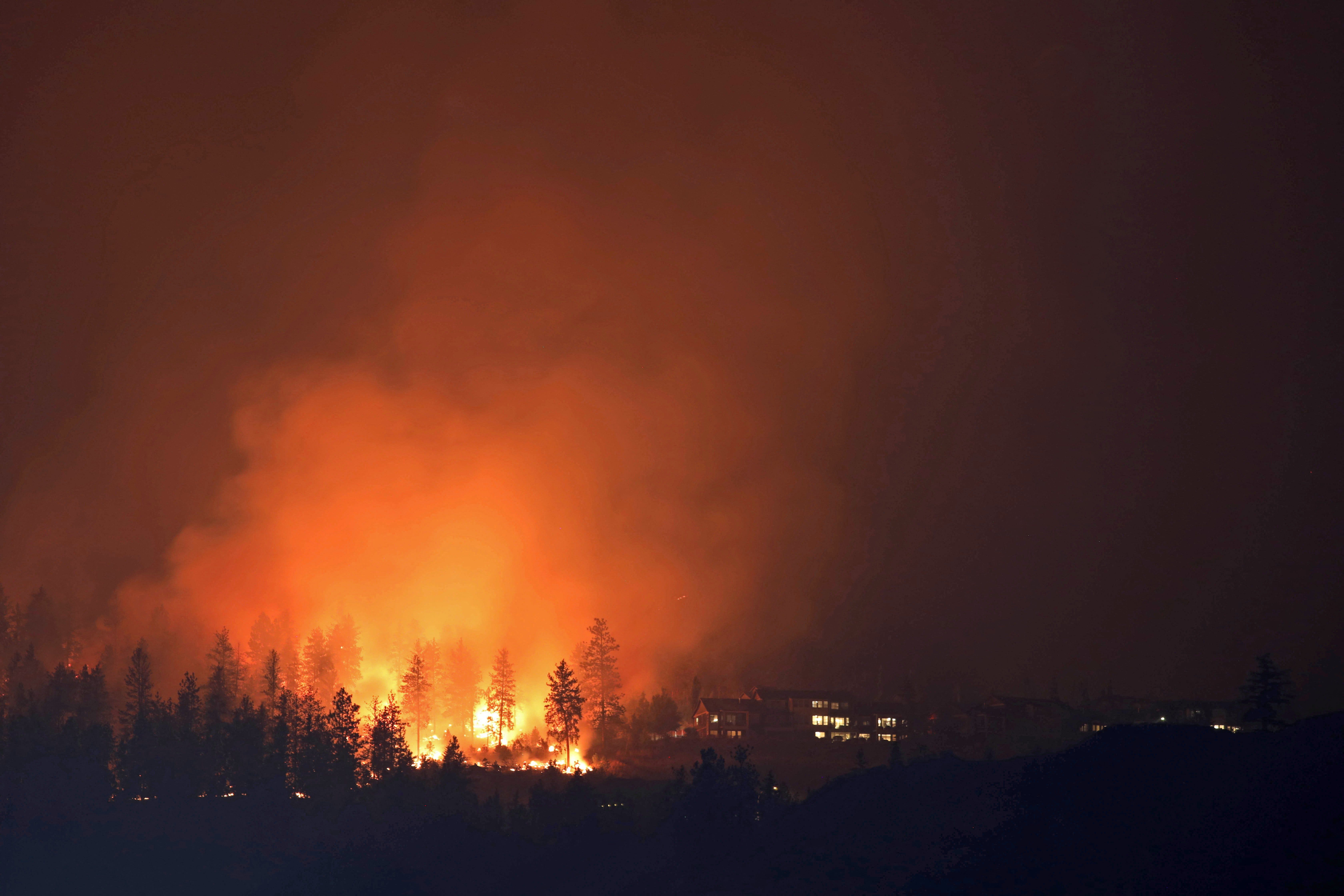 The McDougall Creek wildfire burns next to houses in the Okanagan community of West Kelowna, British Columbia, Canada.