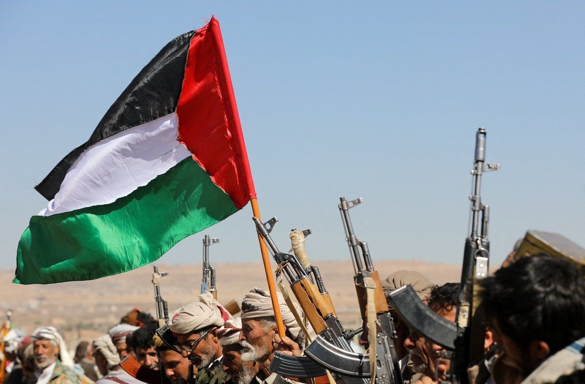 Tribal supporters of Yemen's Houthis wave a Palestinian flag and hold up their firearms during a protest on recent U.S.-led strikes on Houthi targets, near Sanaa, Yemen January 14, 2024.