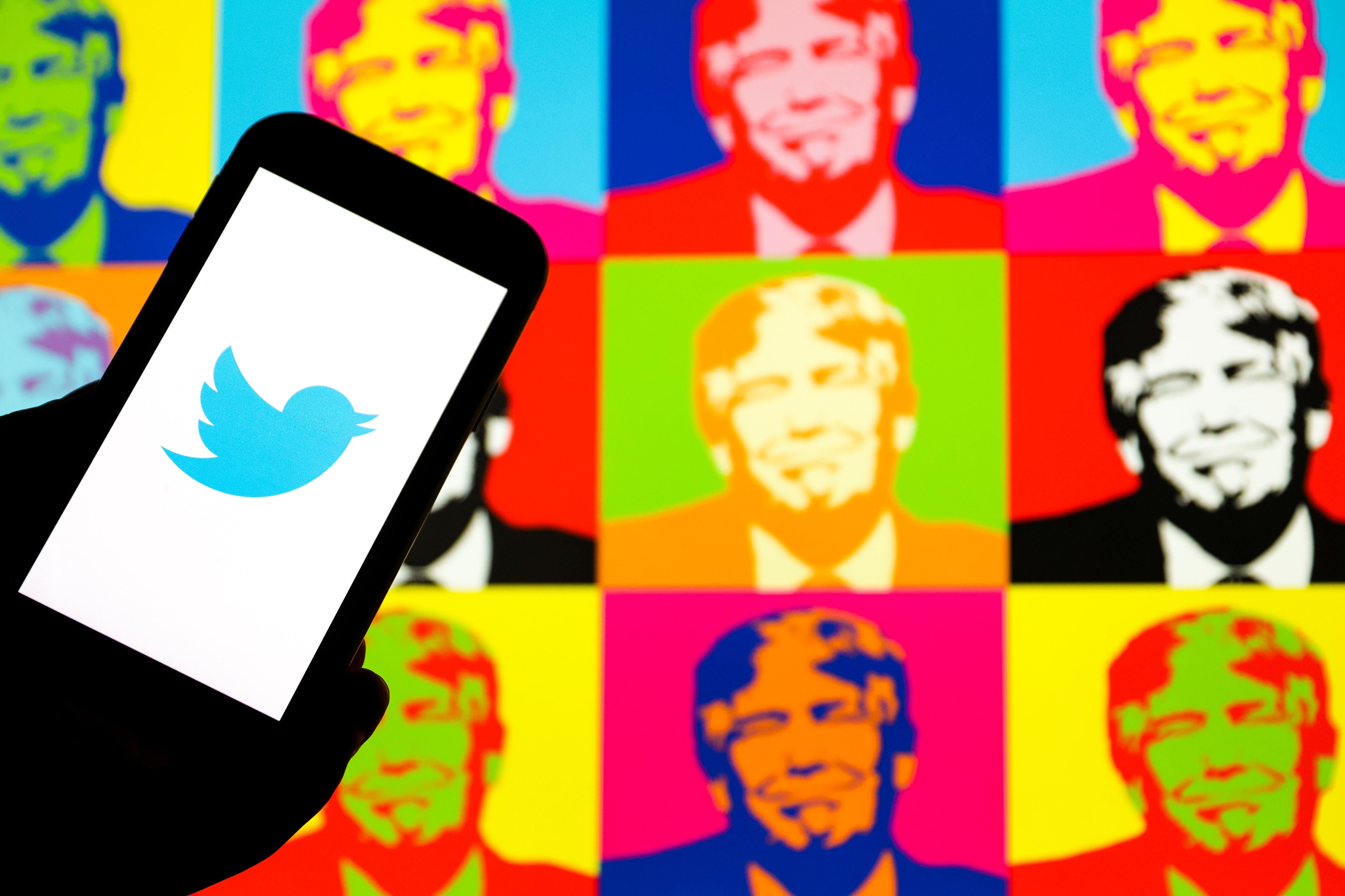 Twitter logo displayed on a smartphone with multiple colorful faces of Donald Trump in the background.