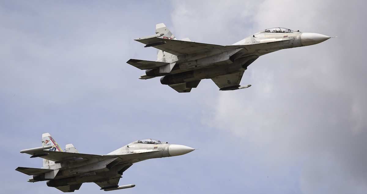 Two military jets fly in formation during the industrial air show.