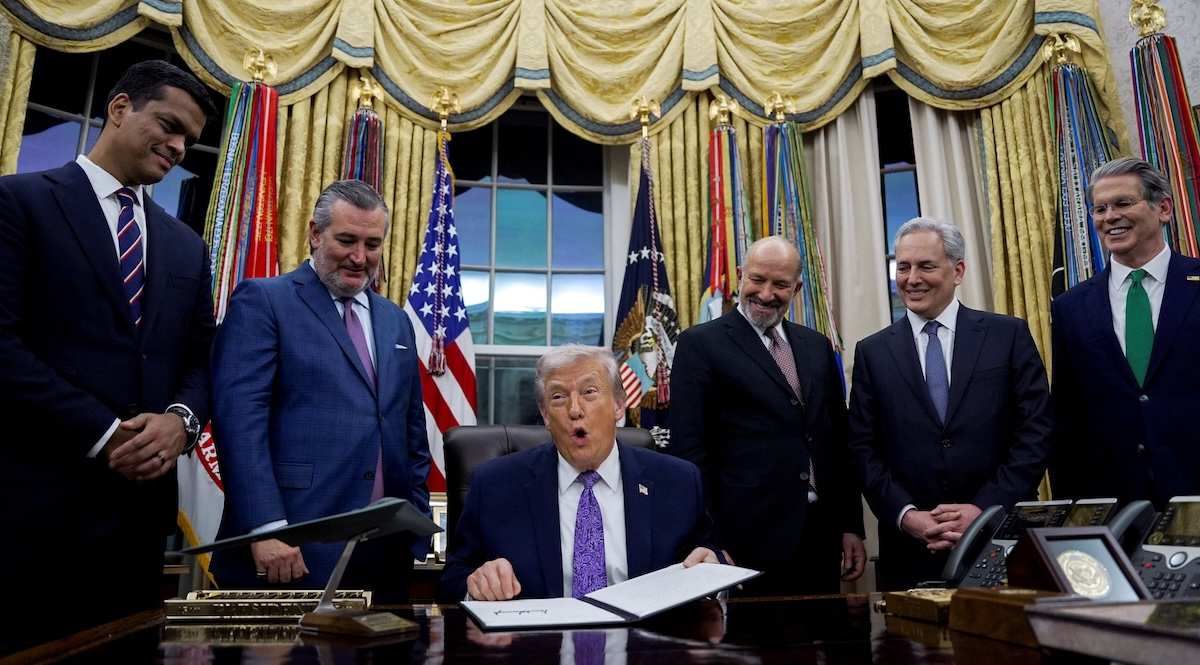 U.S. President Donald Trump holds a signed executive order on AI next to Sriram Krishnan, Senior White House Policy Advisor on Artificial Intelligence on December 11, 2025. 