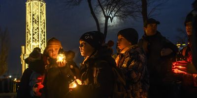 Ukrainians visit a monument to Holodomor victims during a commemoration ceremony marking the 90th anniversary of the famine of 1932-33, against a backdrop of Russian drones attacking Kyiv.
