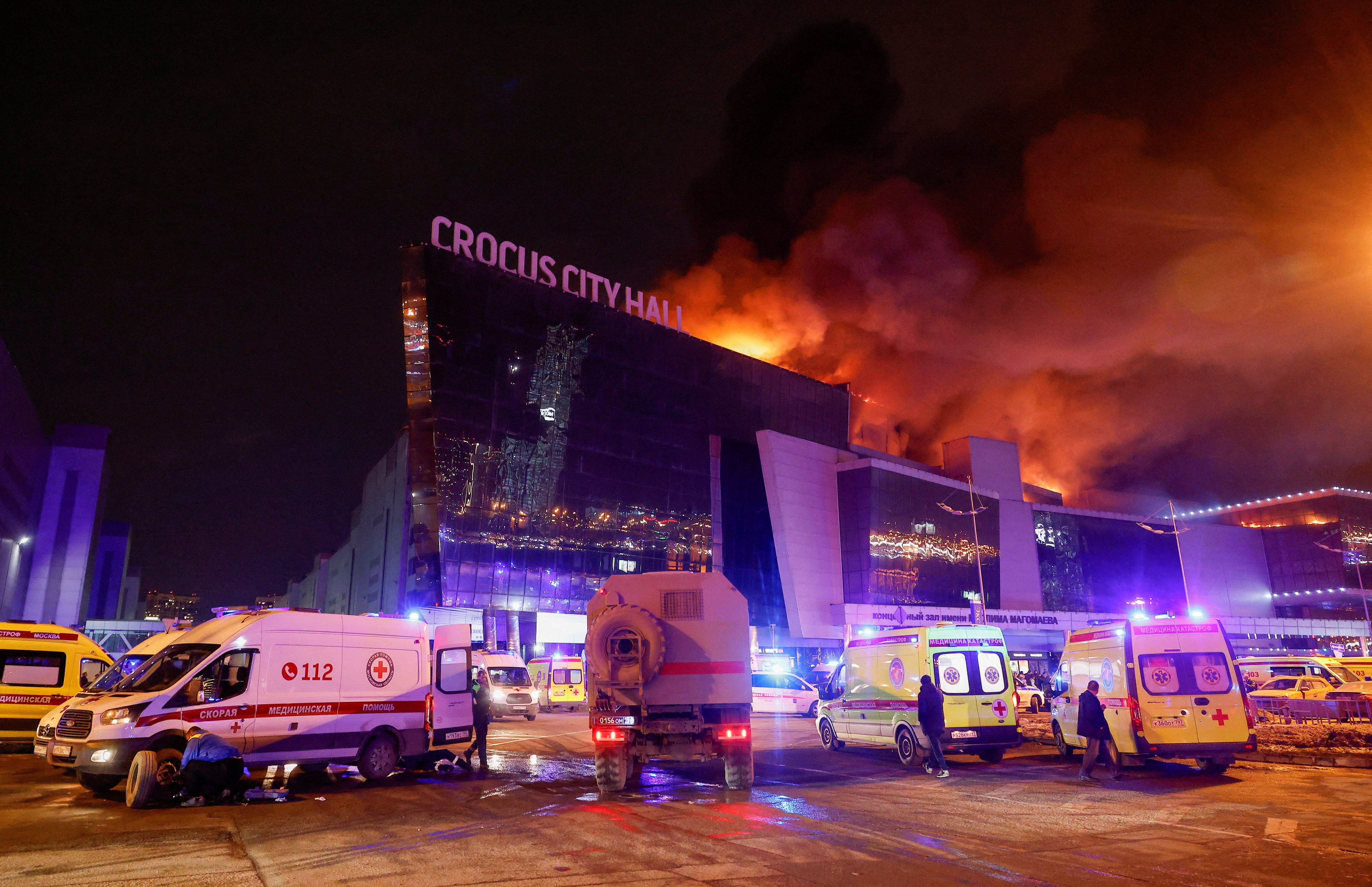 Vehicles of Russian emergency services are parked near the burning Crocus City Hall concert venue following a reported shooting incident, outside Moscow, Russia, March 22, 2024. 