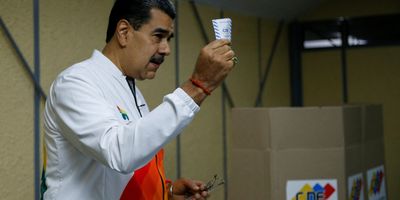 Venezuela's President Nicolas Maduro shows his ballot during a referendum over Venezuela's rights to the potentially oil-rich region of Esequiba in Guyana, in Caracas, Venezuela, on Dec. 3, 2023.