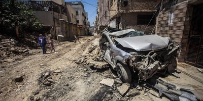 View of a destroyed car on the street caused by an Israeli airstrike on the city of Jenin in the northern occupied West Bank.