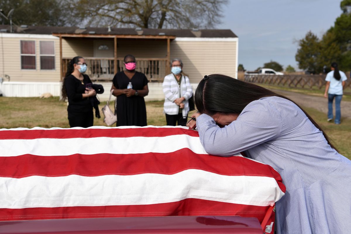 Lila Blanks holds the casket of her husband, Gregory Blanks, 50, who died of the coronavirus disease (COVID-19), ahead of his funeral in San Felipe, Texas, U.S., January 26, 2021.