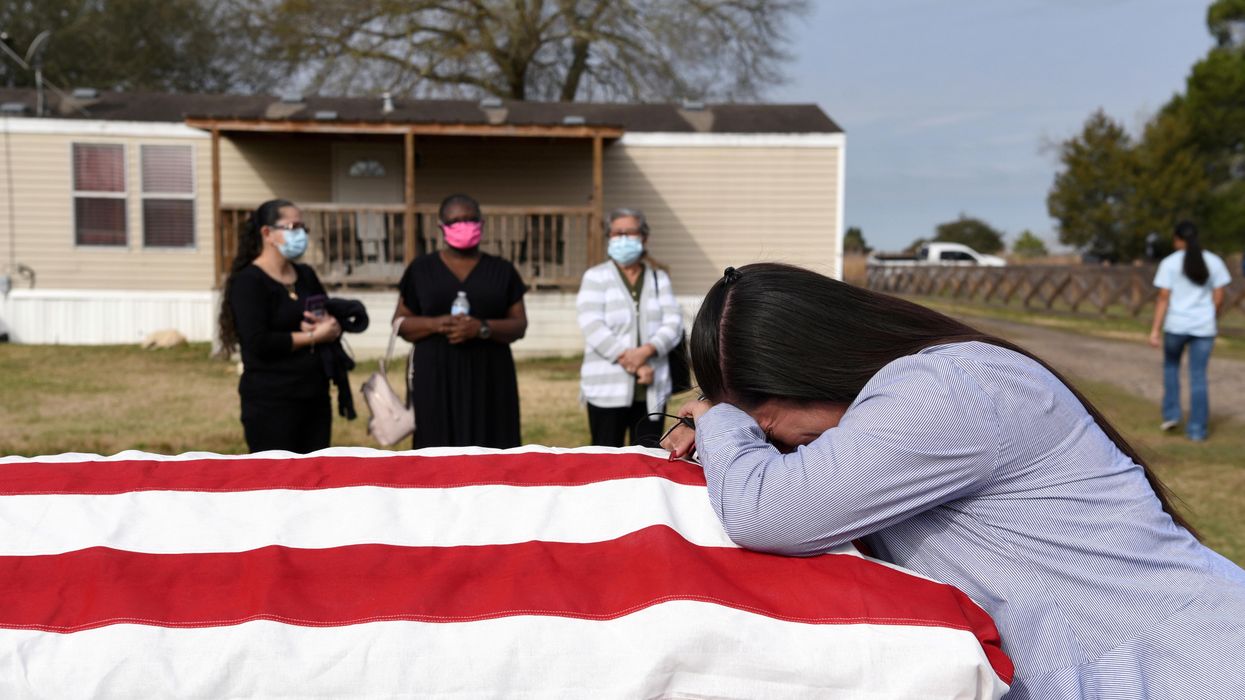 Lila Blanks holds the casket of her husband, Gregory Blanks, 50, who died of the coronavirus disease (COVID-19), ahead of his funeral in San Felipe, Texas, U.S., January 26, 2021.