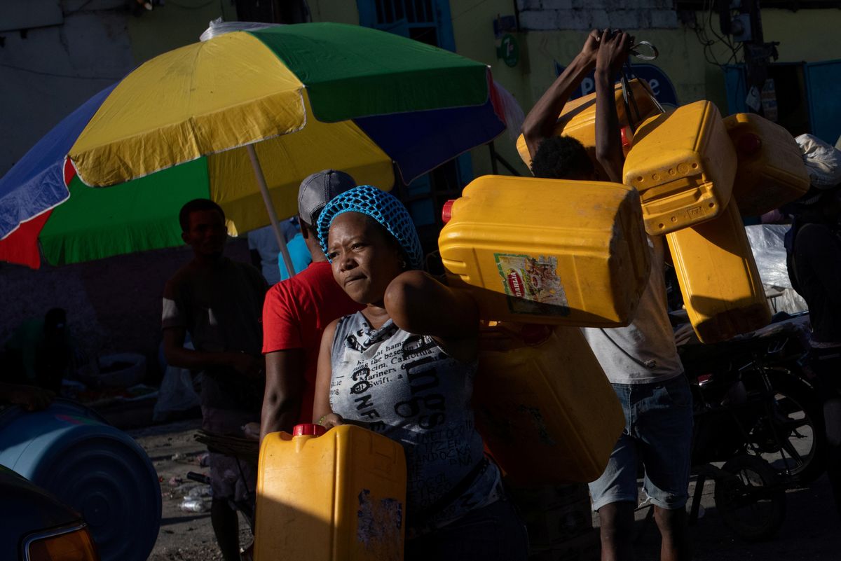 Locals carry containers, used for oil and gasoline, during fuel shortages in Port-au-Prince, Haiti October 24, 2021