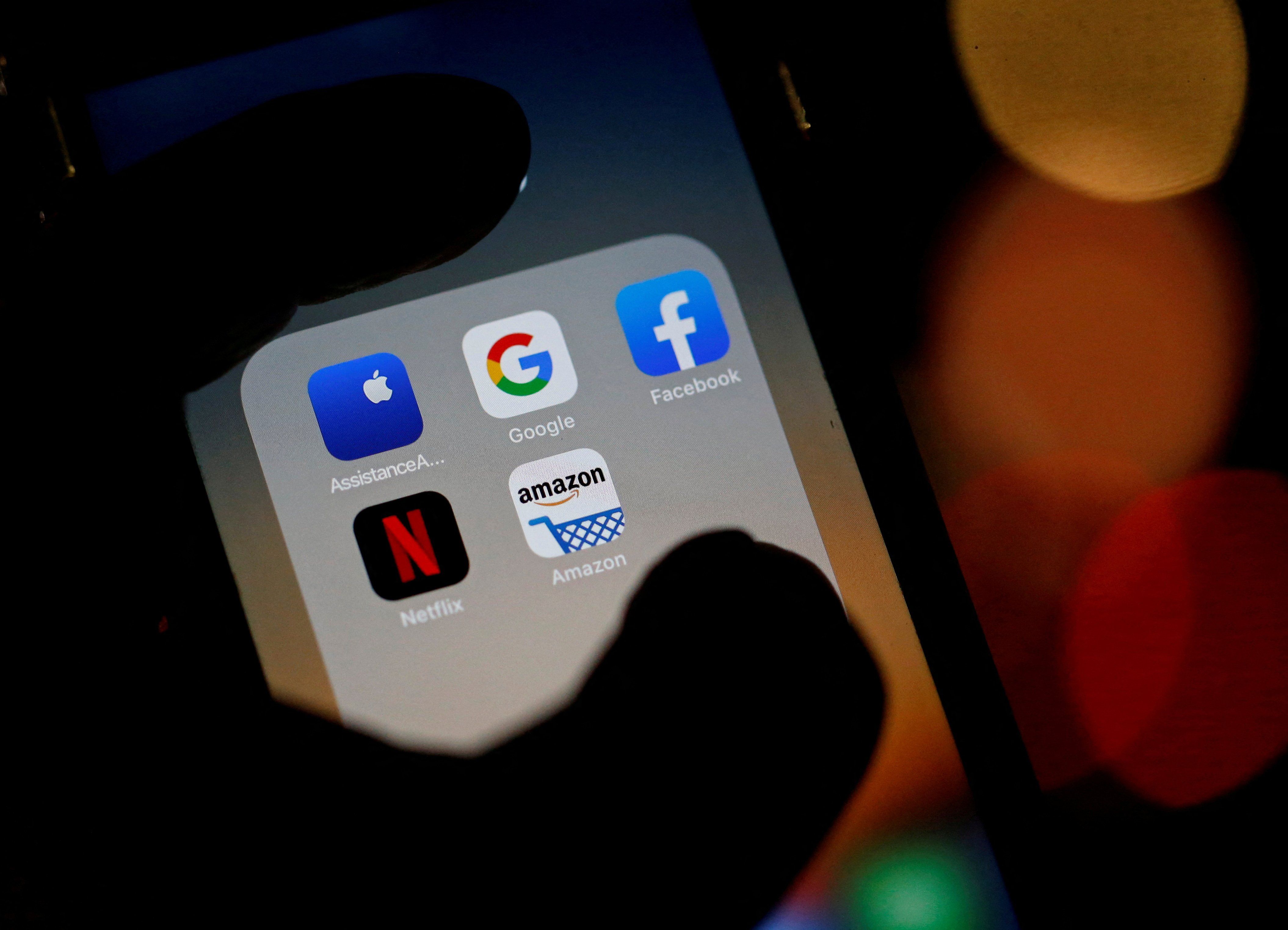 Logos of mobile apps, Google, Amazon, Facebook, Apple, and Netflix displayed on a screen.