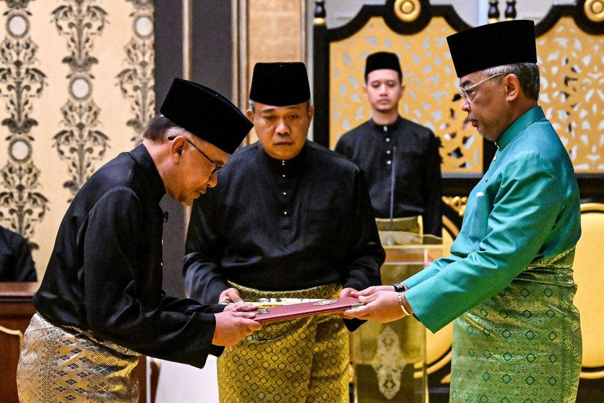 Malaysia's King Sultan Abdullah Sultan Ahmad Shah (R) and newly appointed Prime Minister Anwar Ibrahim (L) take part in the swearing-in ceremony in Kuala Lumpur.