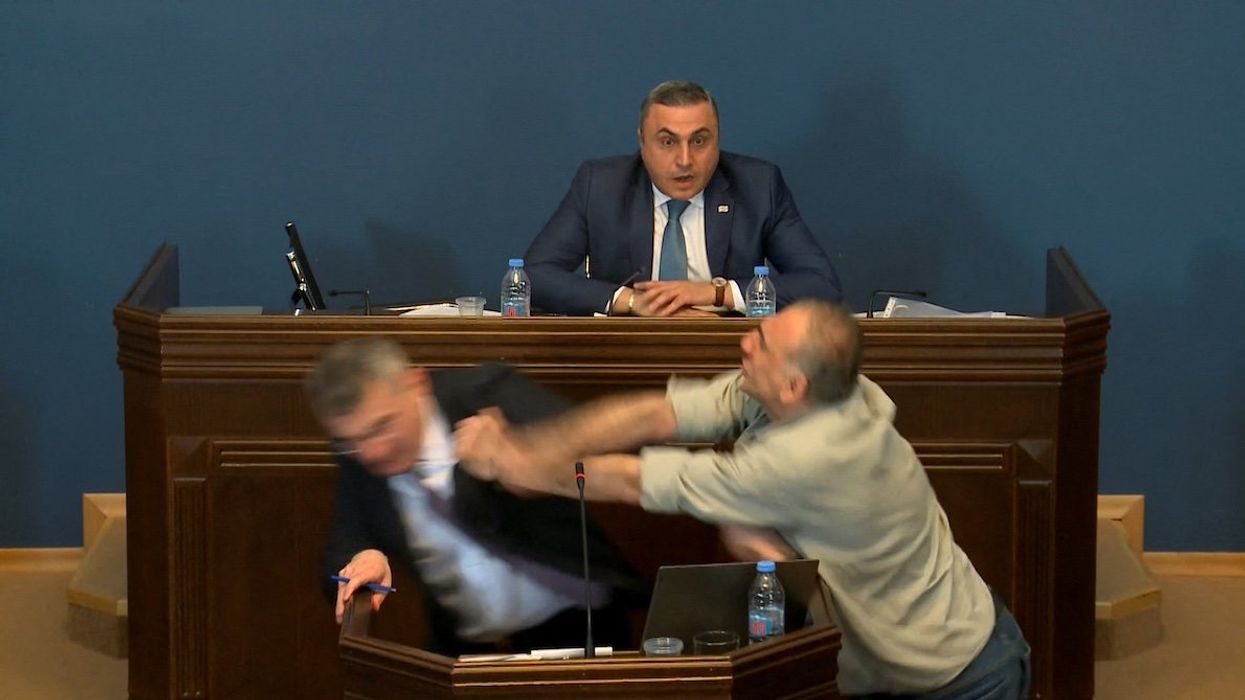 Mamuka Mdinaradze, leader of the ruling Georgian Dream party's parliamentary faction, is punched in the face by opposition MP Aleko Elisashvili during discussion of the bill on "foreign agents" in the Parliament, Tbilisi, Georgia, April 15, 2024 in this still image taken from a live broadcast video.