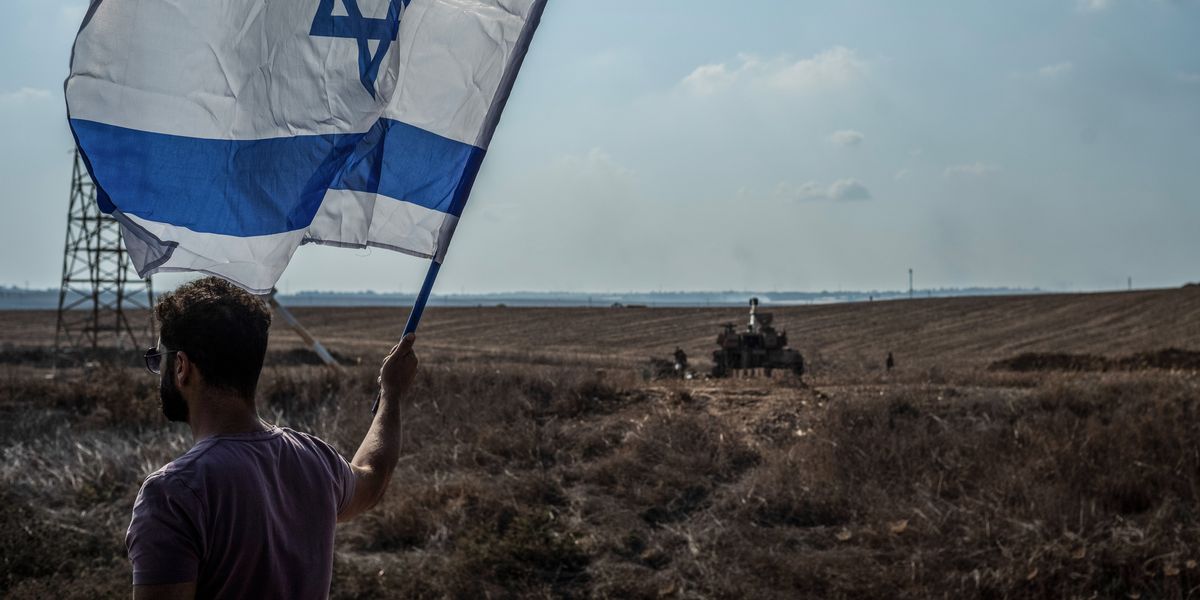 man-holding-israeli-flag-against-the-bac