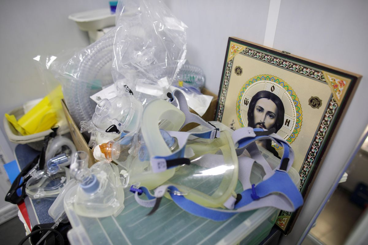 Masks used in the COVID-19 ICU unit at Giurgiu County Emergency Hospital are backdropped by an icon with a Christian orthodox depiction of Jesus Christ, in Giurgiu, Romania, November 4, 2021.