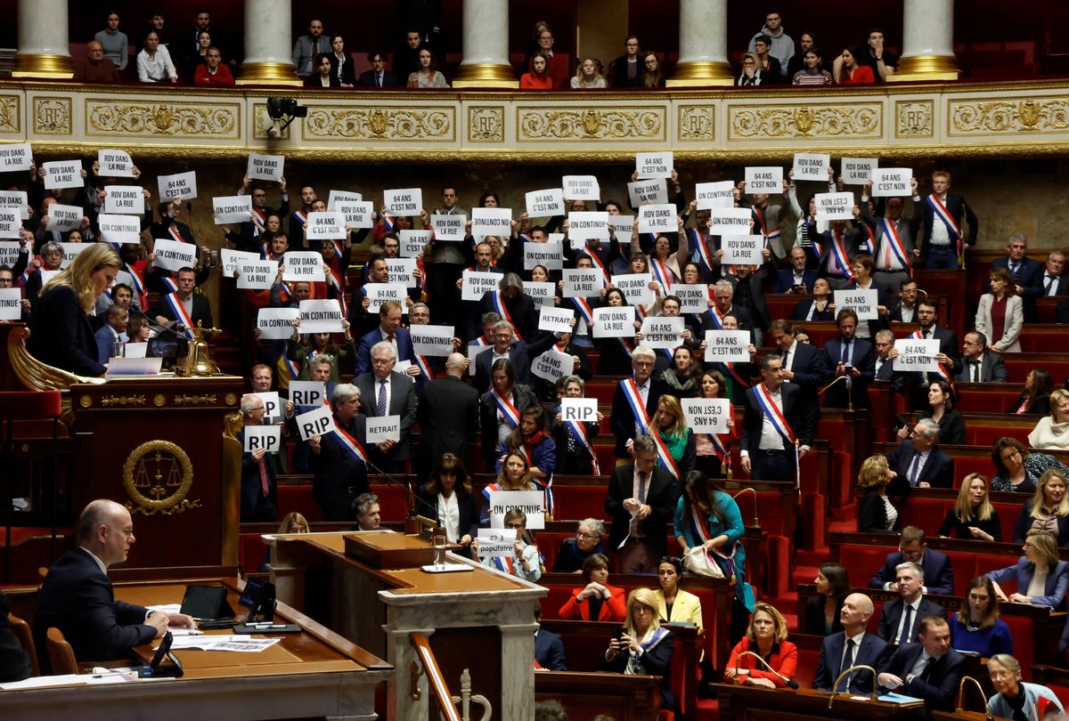 Members of parliament hold placards after the result of the vote on the first motion of no-confidence against the French government at the National Assembly in Paris, France, March 20, 2023.