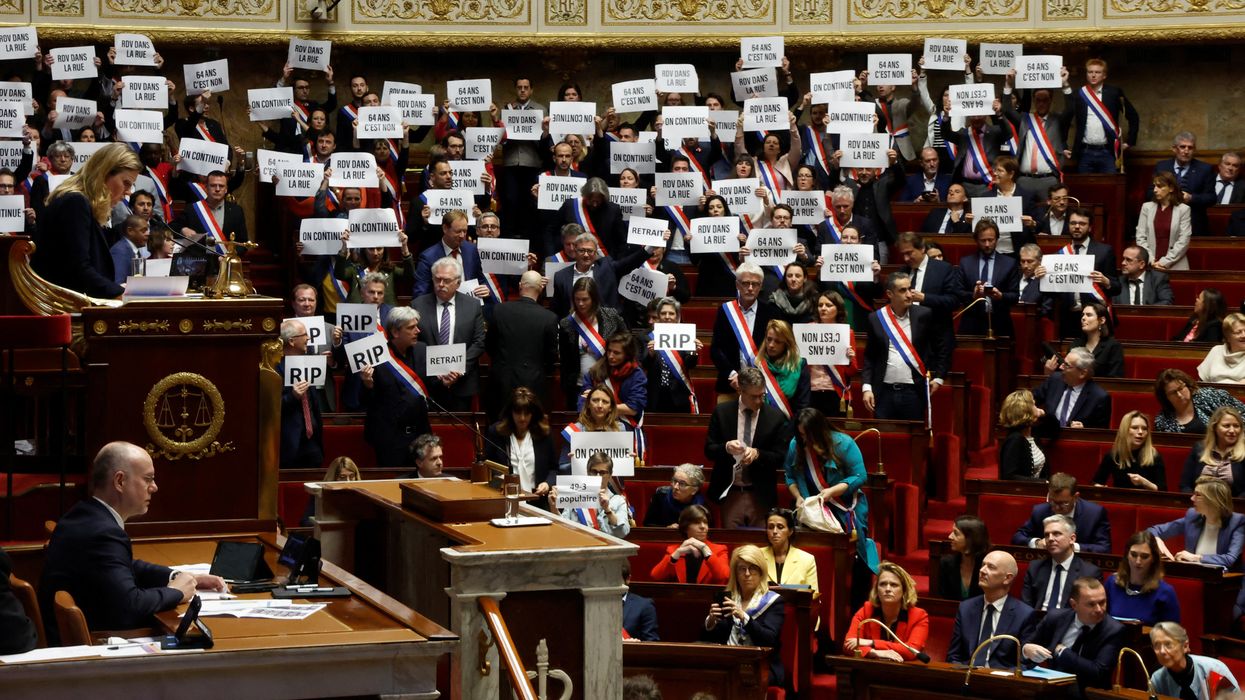 Members of parliament hold placards after the result of the vote on the first motion of no-confidence against the French government at the National Assembly in Paris, France, March 20, 2023.