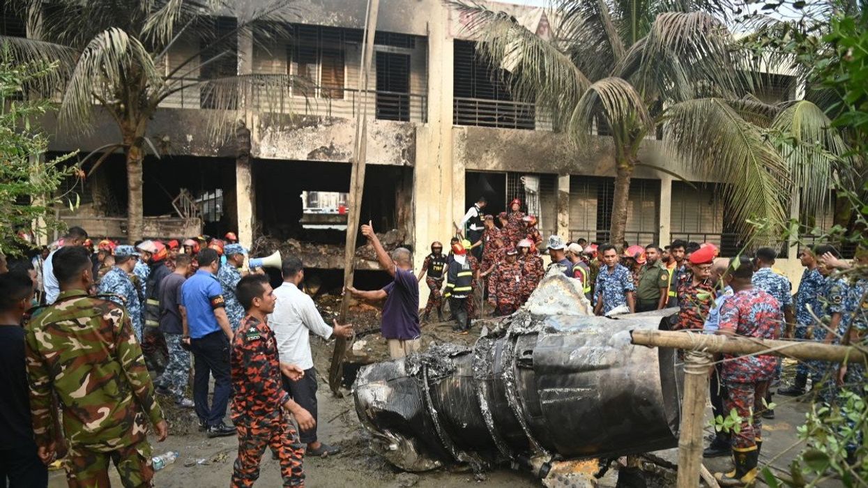 Members of the Bangladesh Army and the fire service start rescue operations after a Bangladesh Air Force F7 aircraft crashed into a building of Milestone College in Dhaka's Uttara around 1:30 pm on July 21, 2025 in Dhaka, Bangladesh