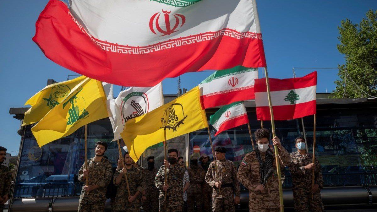 ​Members of the Basij paramilitary force hold Iranian flag, Lebanese flag, and various militia flags, during a rally commemorating International Quds Day in downtown Tehran, April 14, 2023.