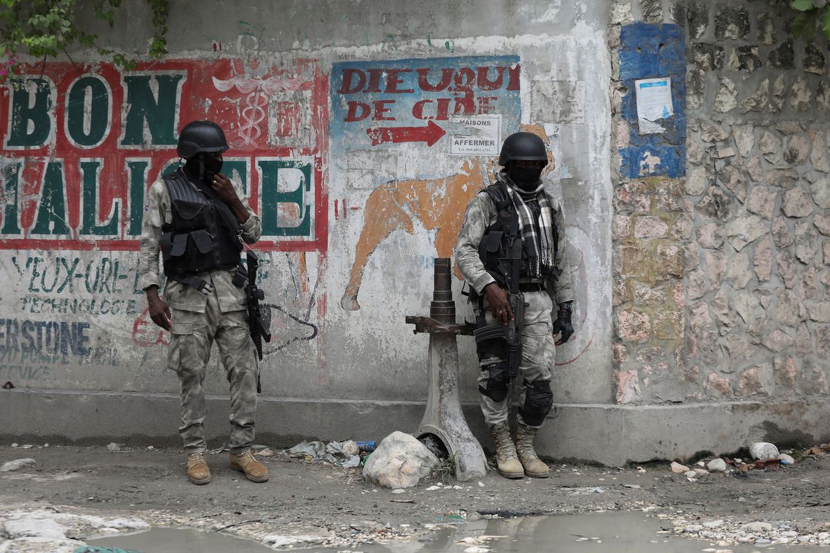 Members of the Haitian National Police patrol a street amid ongoing gun battles between rival gangs. 