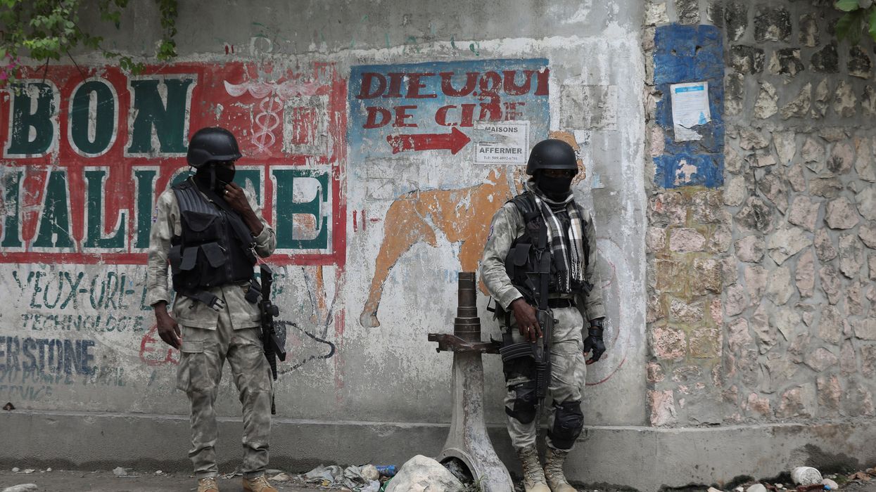Members of the Haitian National Police patrol a street amid ongoing gun battles between rival gangs.