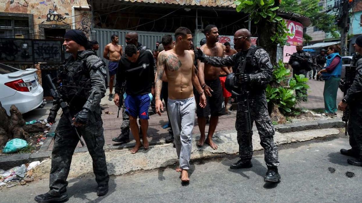 Members of the military police special unit detain suspected drug dealers at the favela do Penha, in Rio de Janeiro, Brazil, on October 28, 2025.
